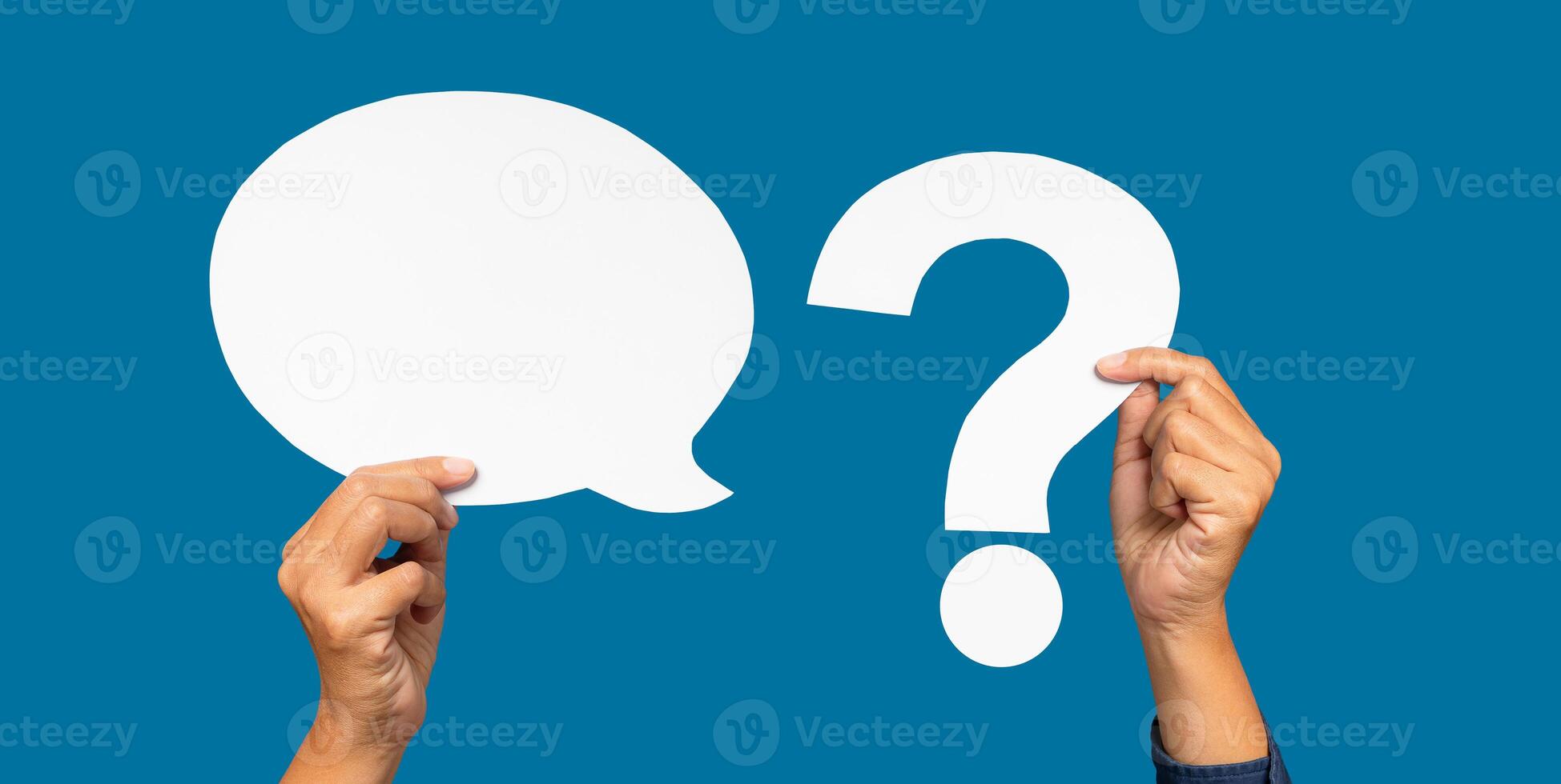 A speech bubble and question mark symbol concept. Hand holding a blank white speech bubble and a white question mark against a blue background. photo