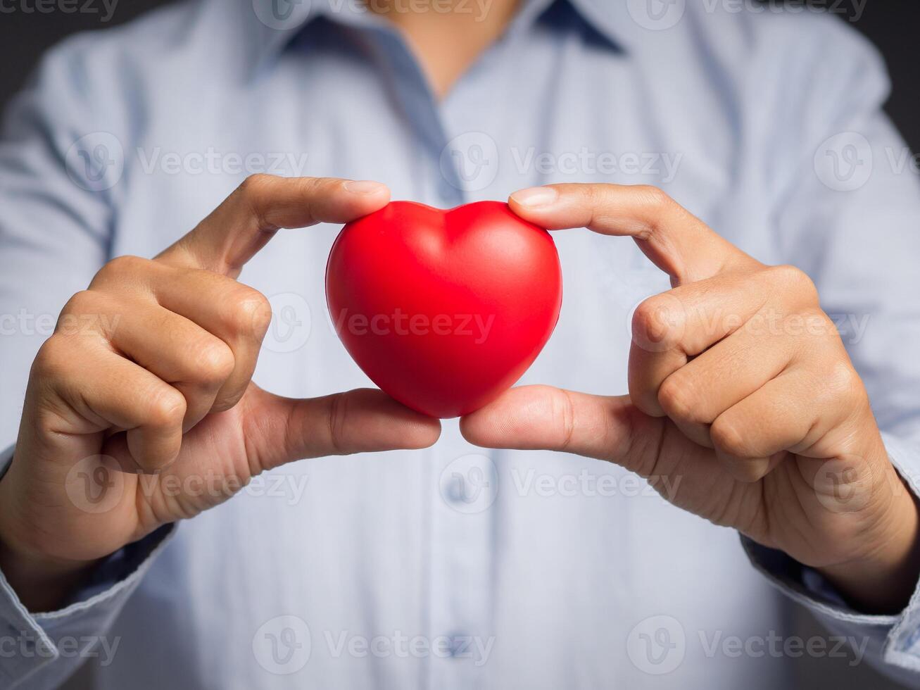 Close-up of hand holding a red heart shape photo