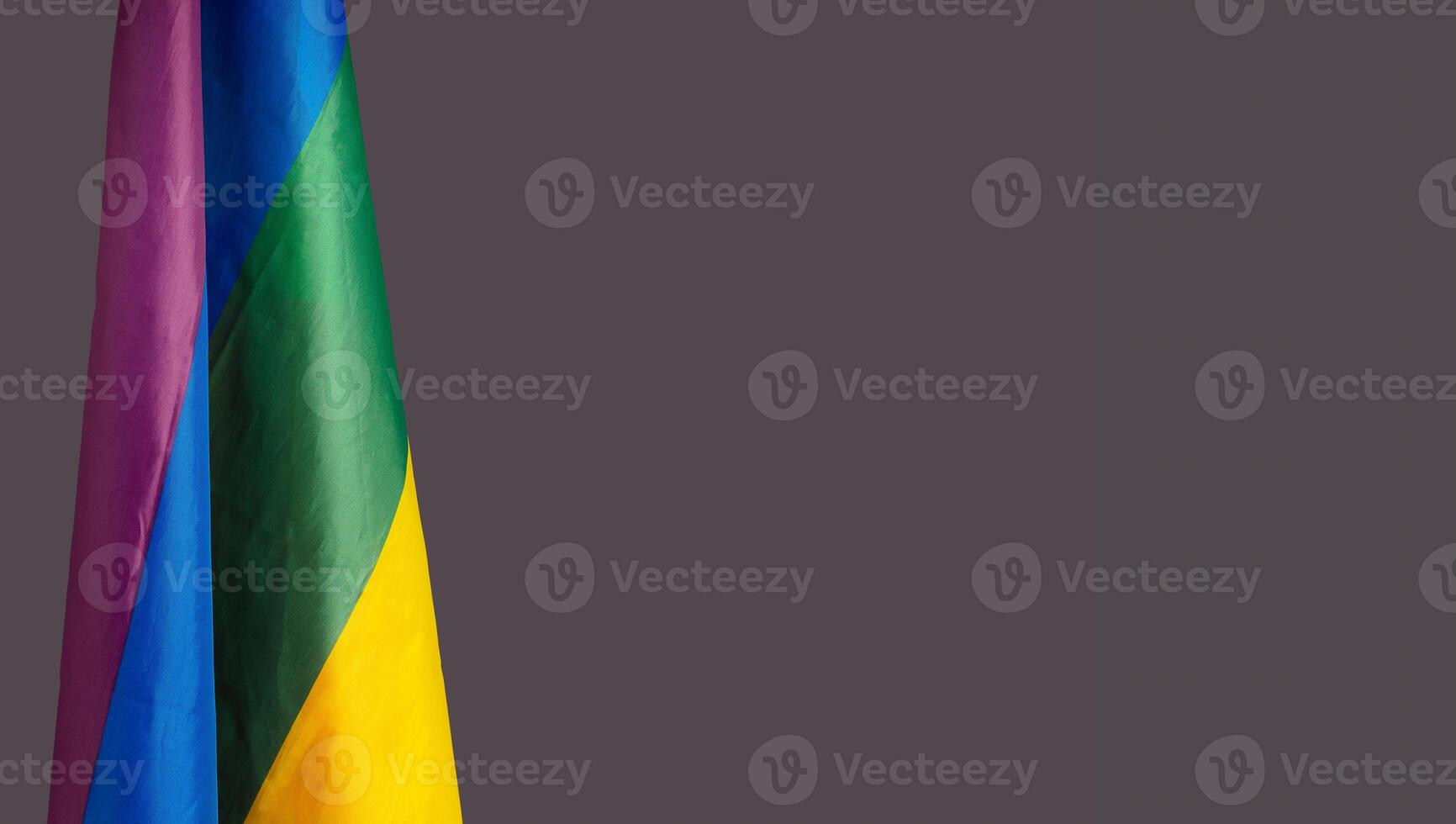 Close-up of the rainbow flag or LGBT flag is on the left side on a gray background photo