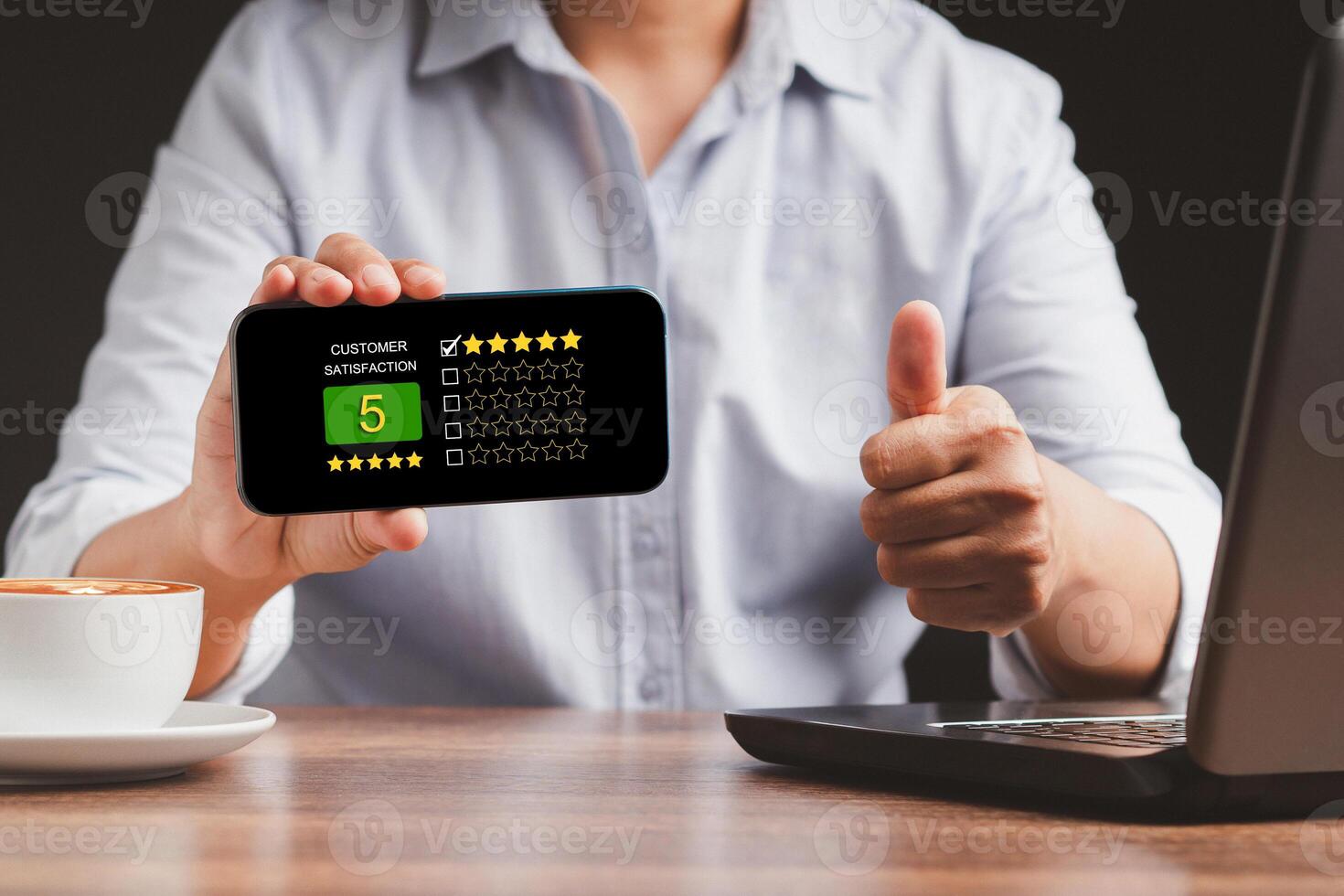Man thumb up and showing a smartphone the five-star icon a rating of very impressed for service photo
