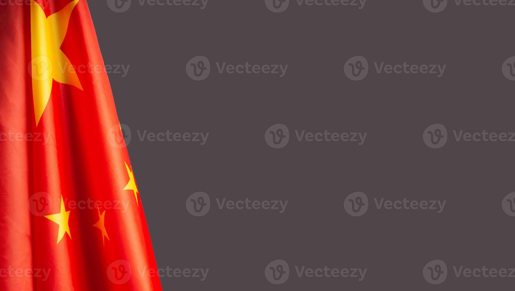 Close-up of the Chinese flag is on the left side on a gray background photo