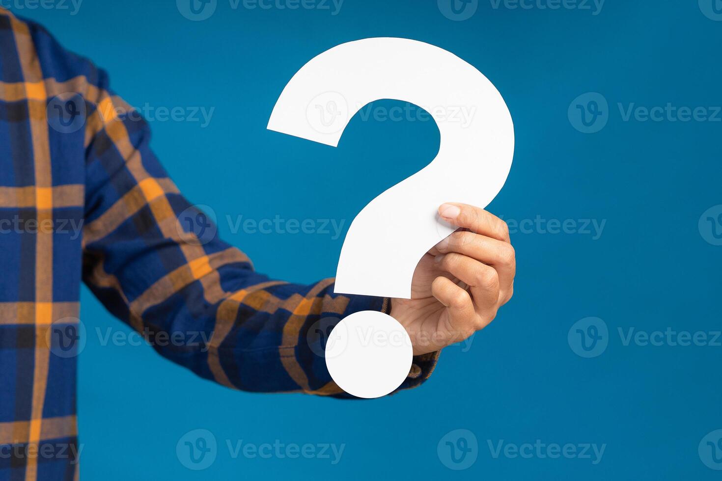 Hand holding a white question mark against a blue background photo