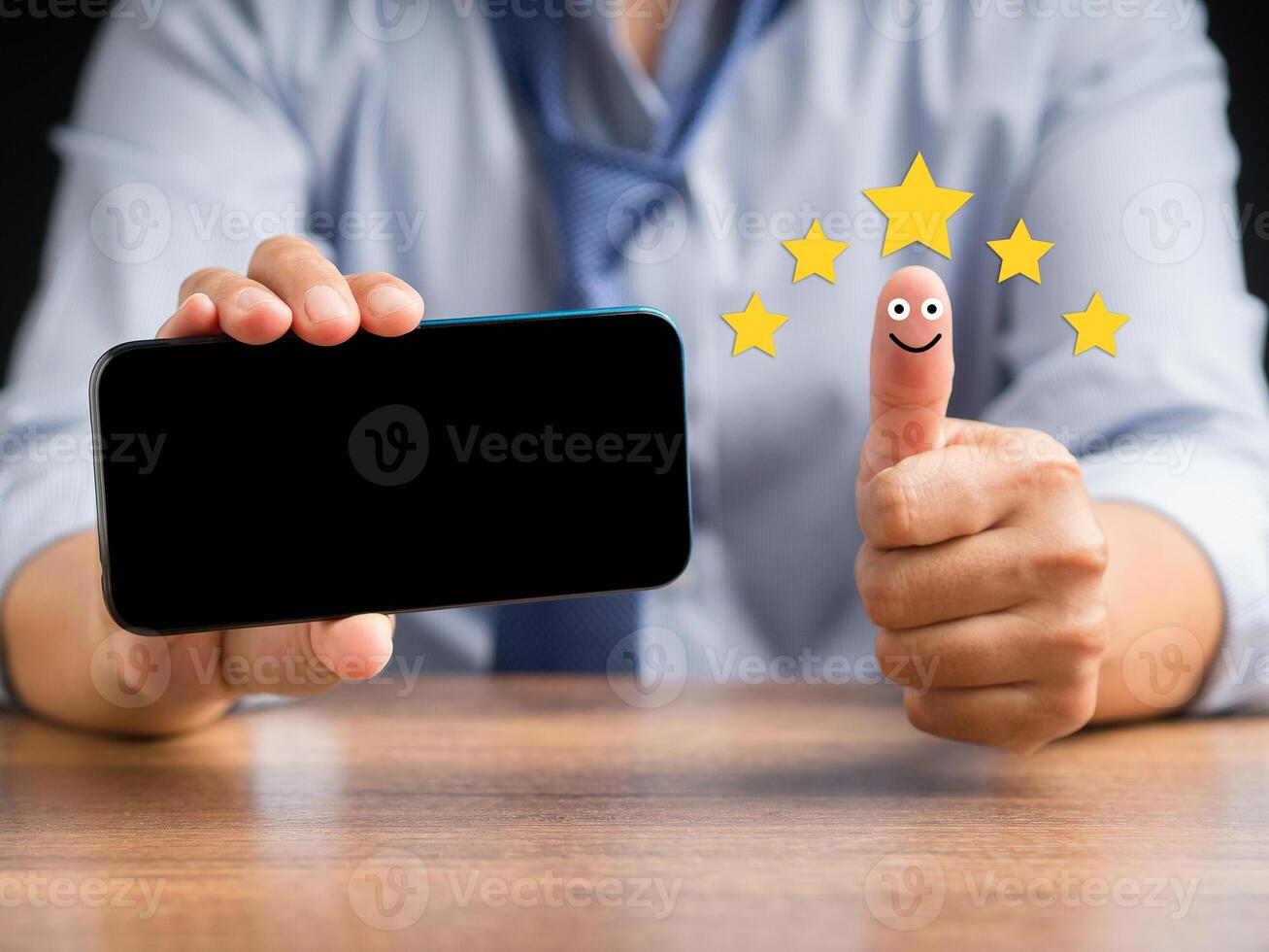Hand with thumb up for smiley face icon and holding a smartphone photo