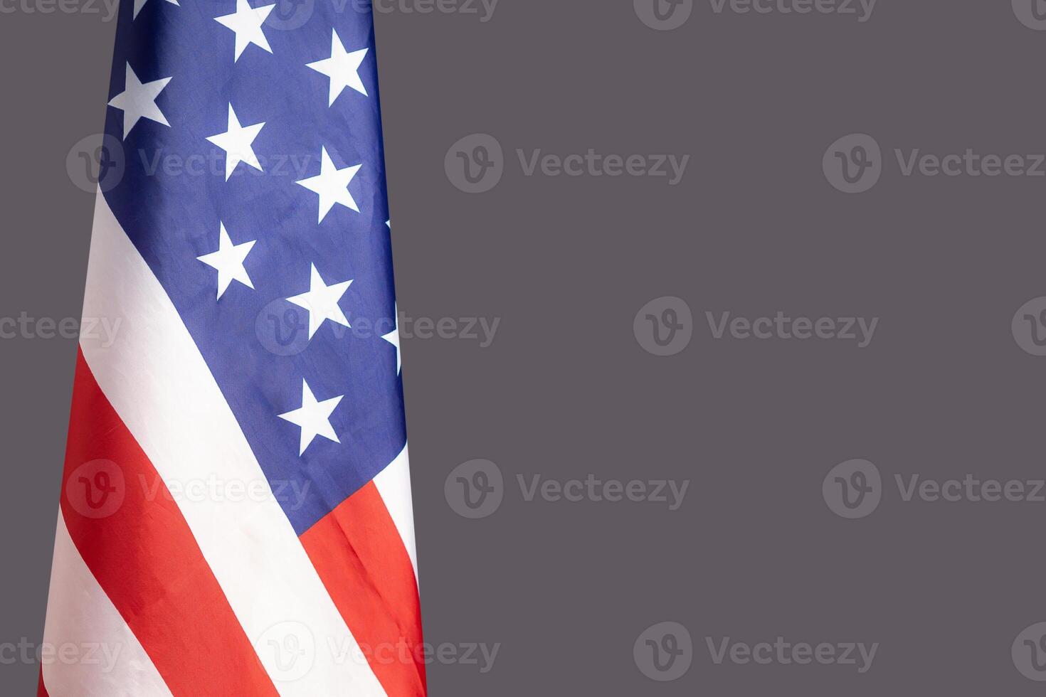 Close-up of the American flag is on the left side on a gray background photo
