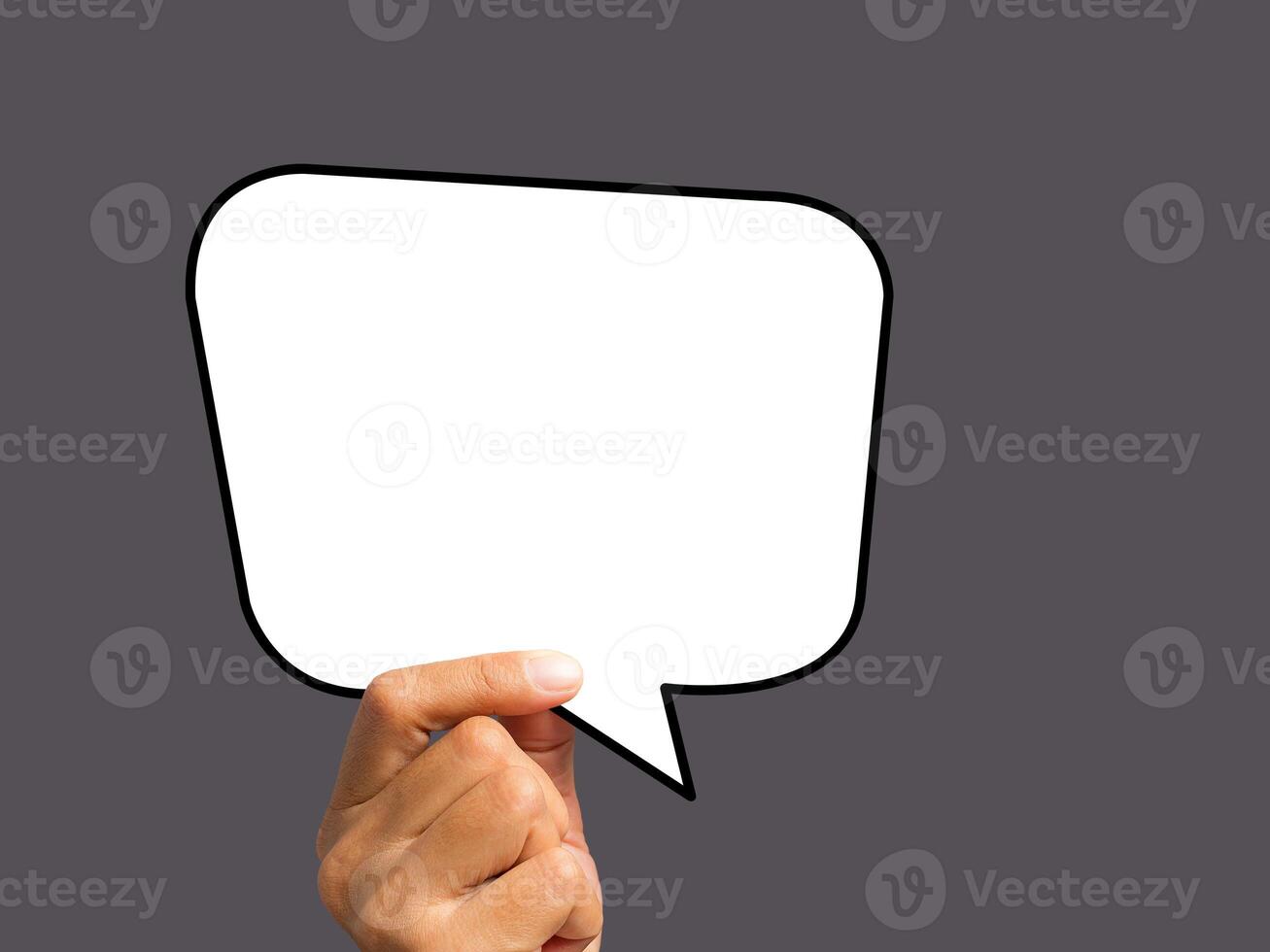 Hand holding of an empty white speech bubble against a gray background photo