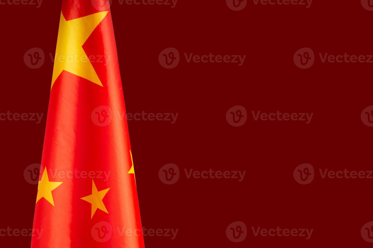 Close-up of the Chinese flag is on the left side on a red background photo