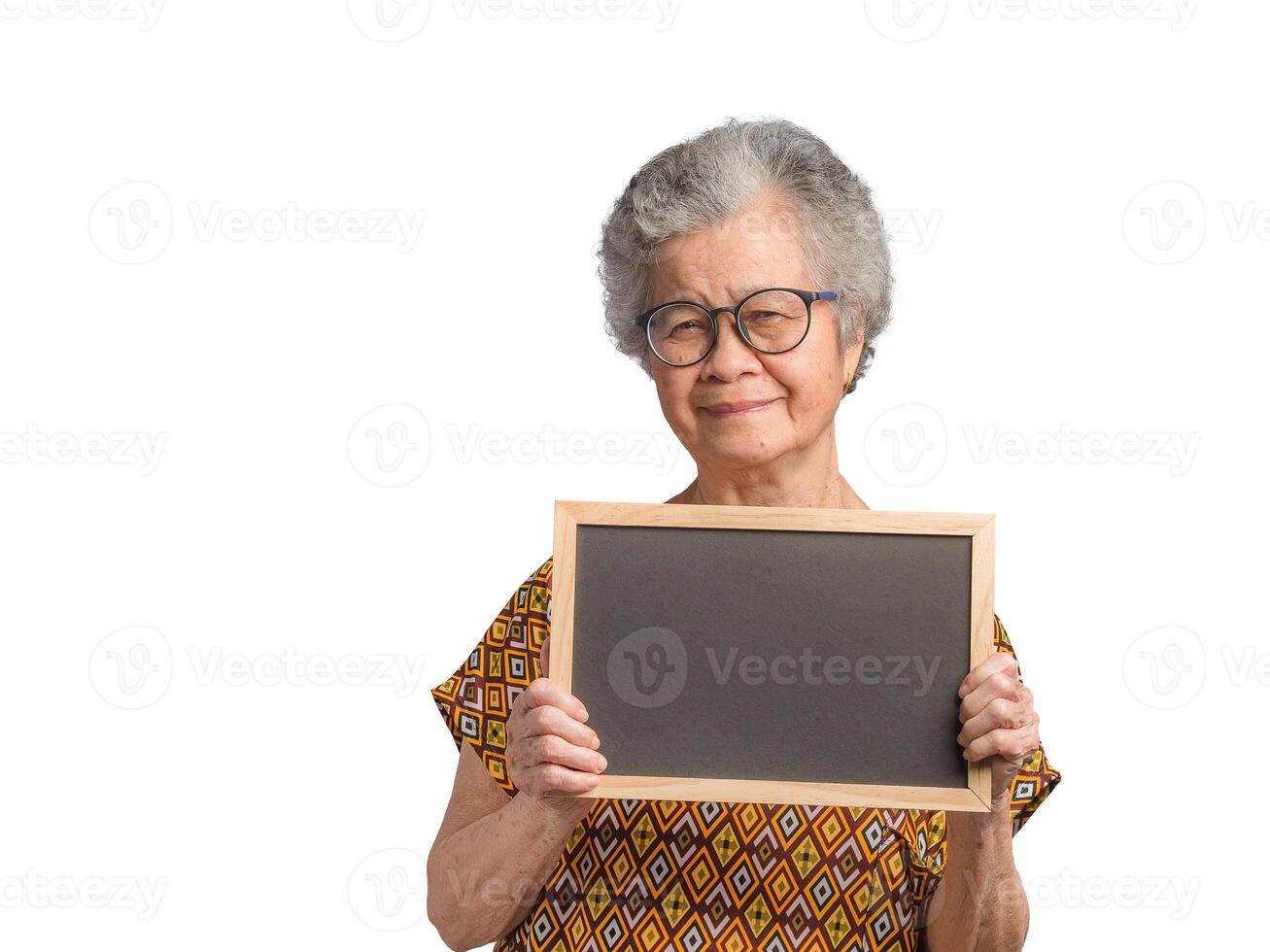 Elderly Asian woman holding a mini blackboard and looking at the camera with a smile while standing on a white background photo