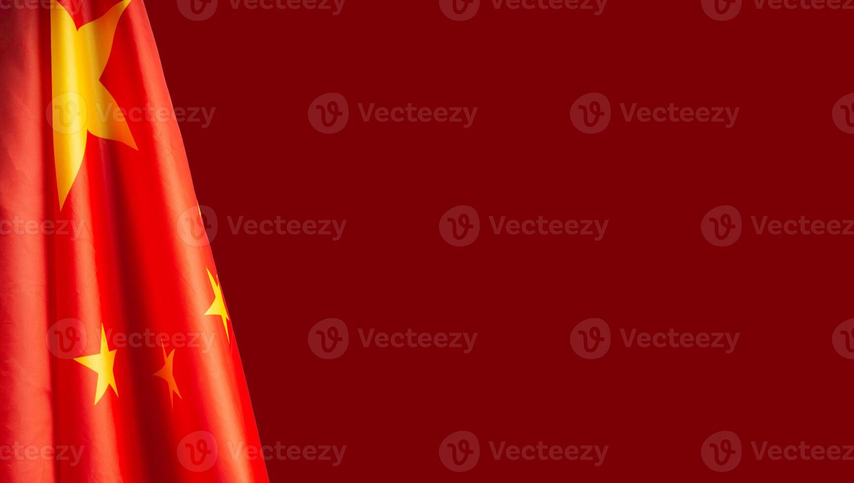 Close-up of the Chinese flag is on the left side on a red background photo