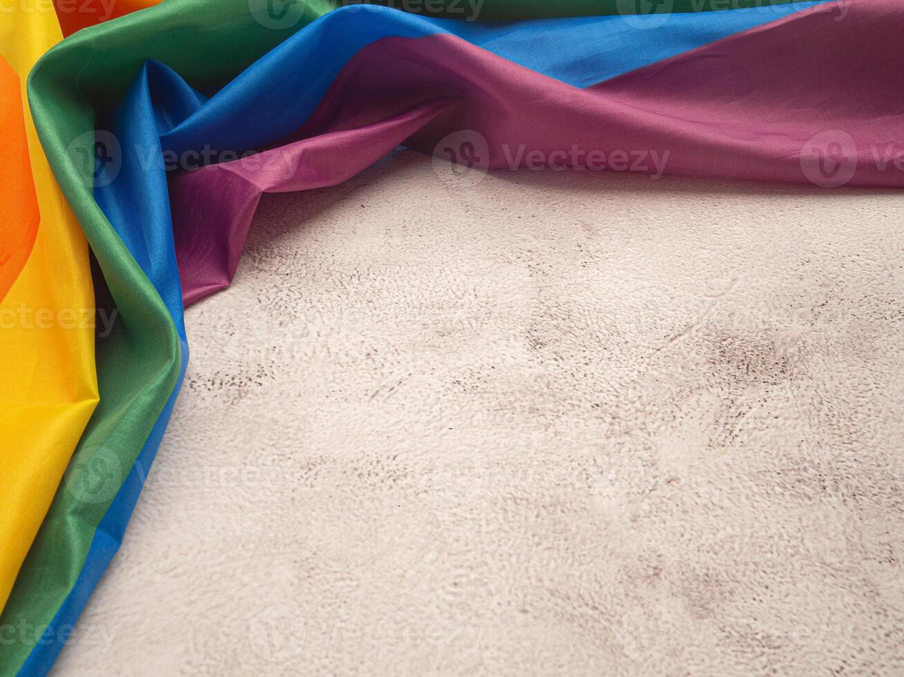 Top view of the rainbow flag or LGBT flag is on a cement floor with copy space. photo