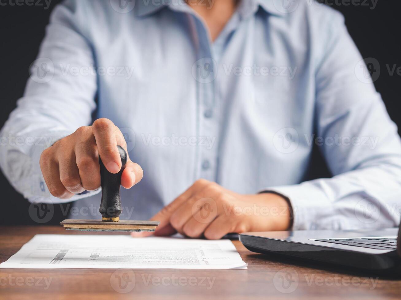 Businessman stamping approved on documents while sitting working in the office photo