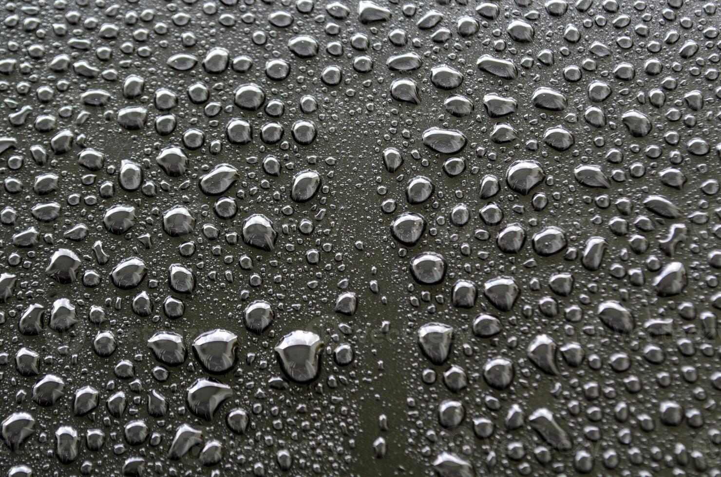 Close up view of rain droplets on dark cover background. Rain droplets and wallpaper design concept photo