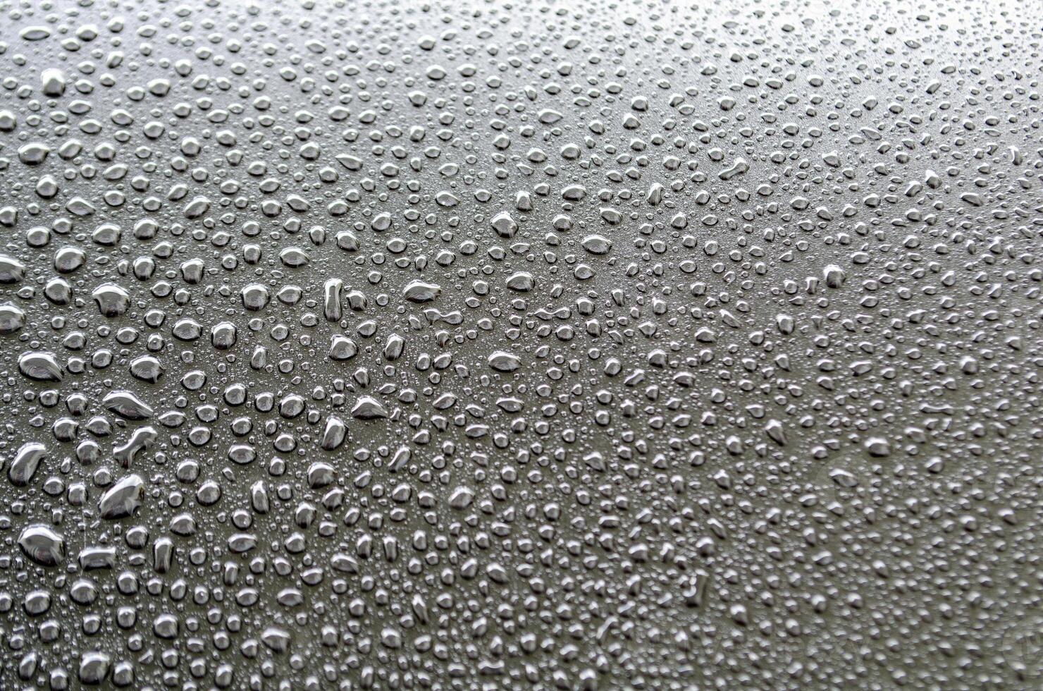 Straight view of rain droplets on dark cover background. Rain droplets and wallpaper design concept photo