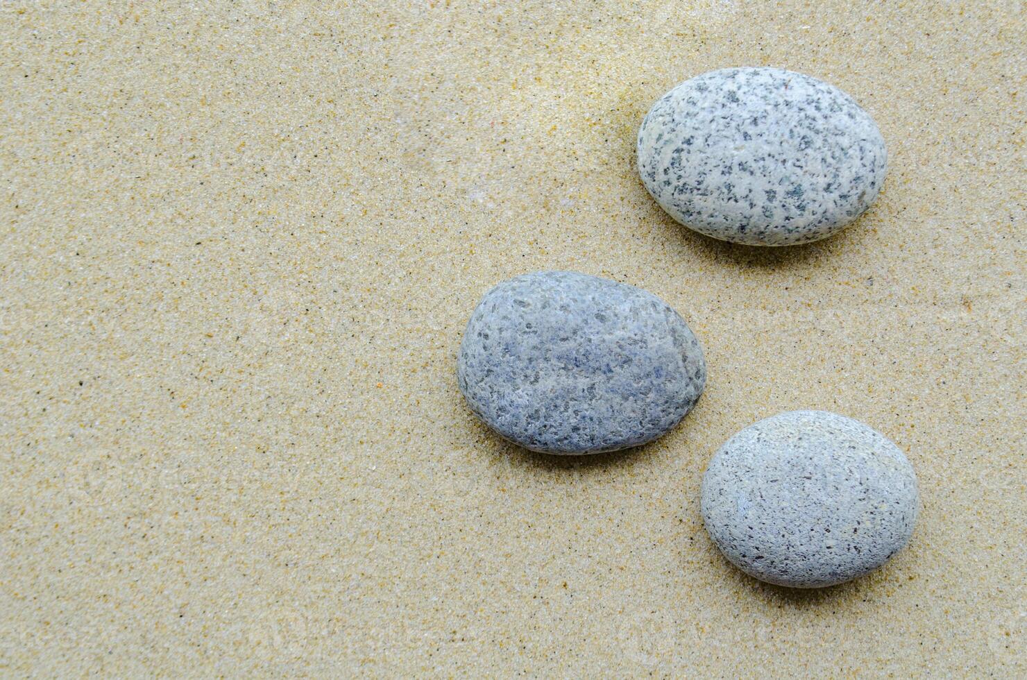 Top view of stones on beach sand with customizable space for text or ideas photo