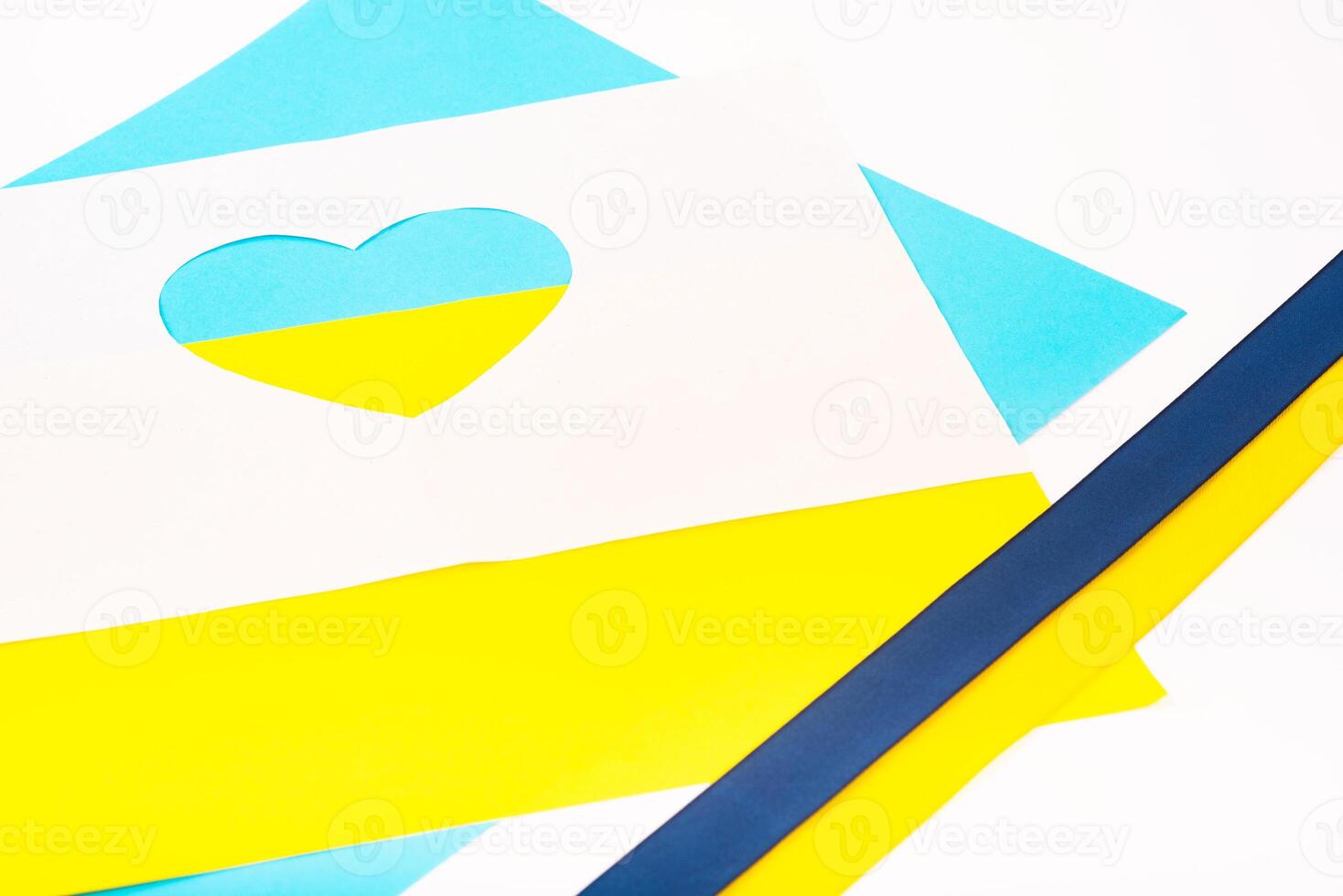 heart cut out of paper and painted in blue and yellow colors and ribbon of flag. Creativity as support of Ukraine photo