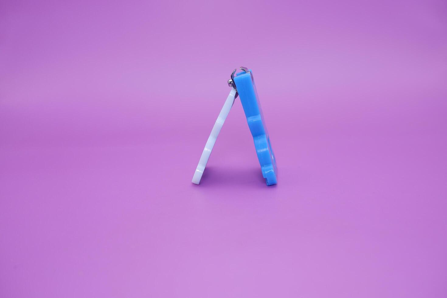 cute nail clippers isolated on purple background. cute nail clippers with blue and white color combination photo