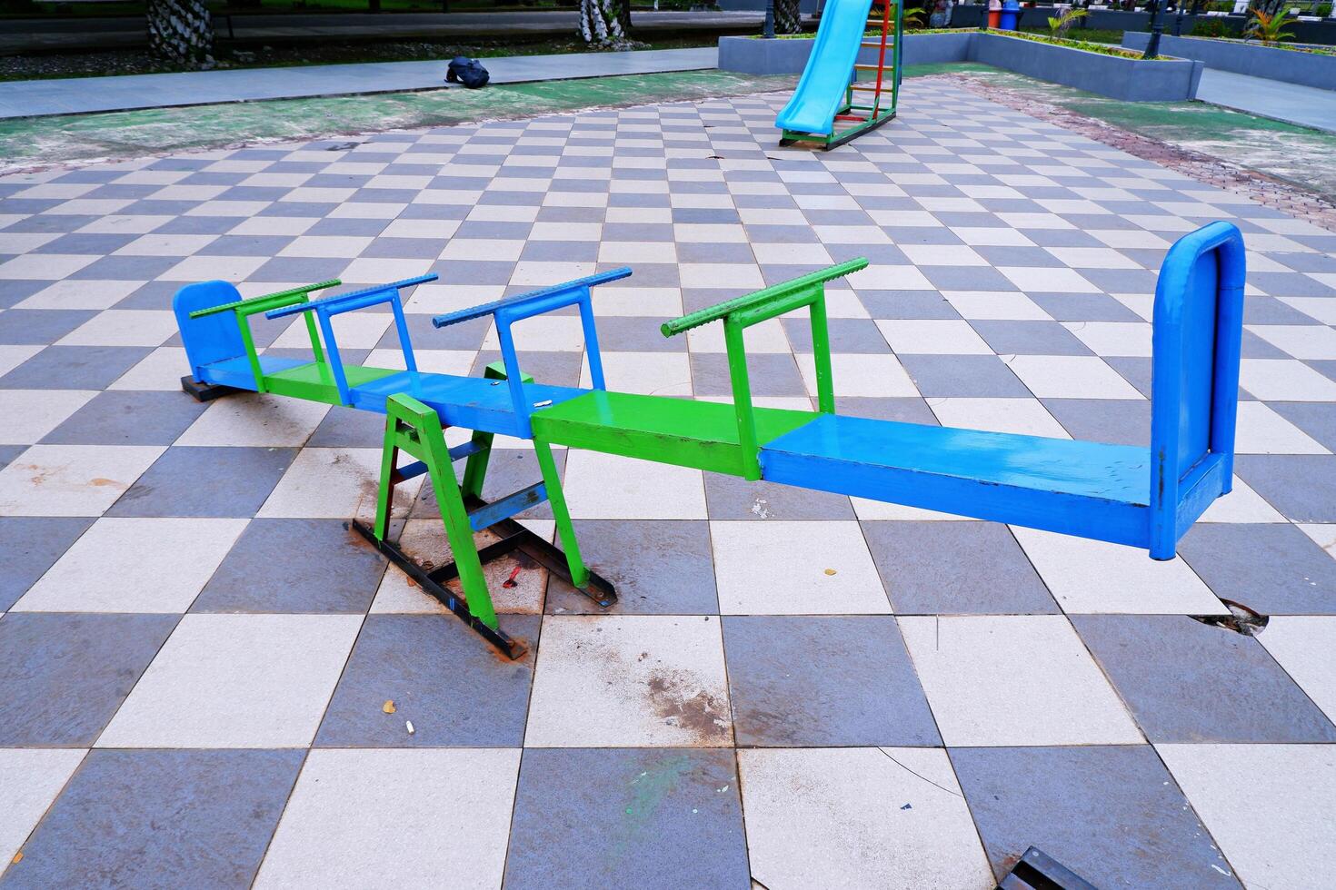 seesaw that can be played by 4 children. seesaw with a combination of blue and green colors. photo