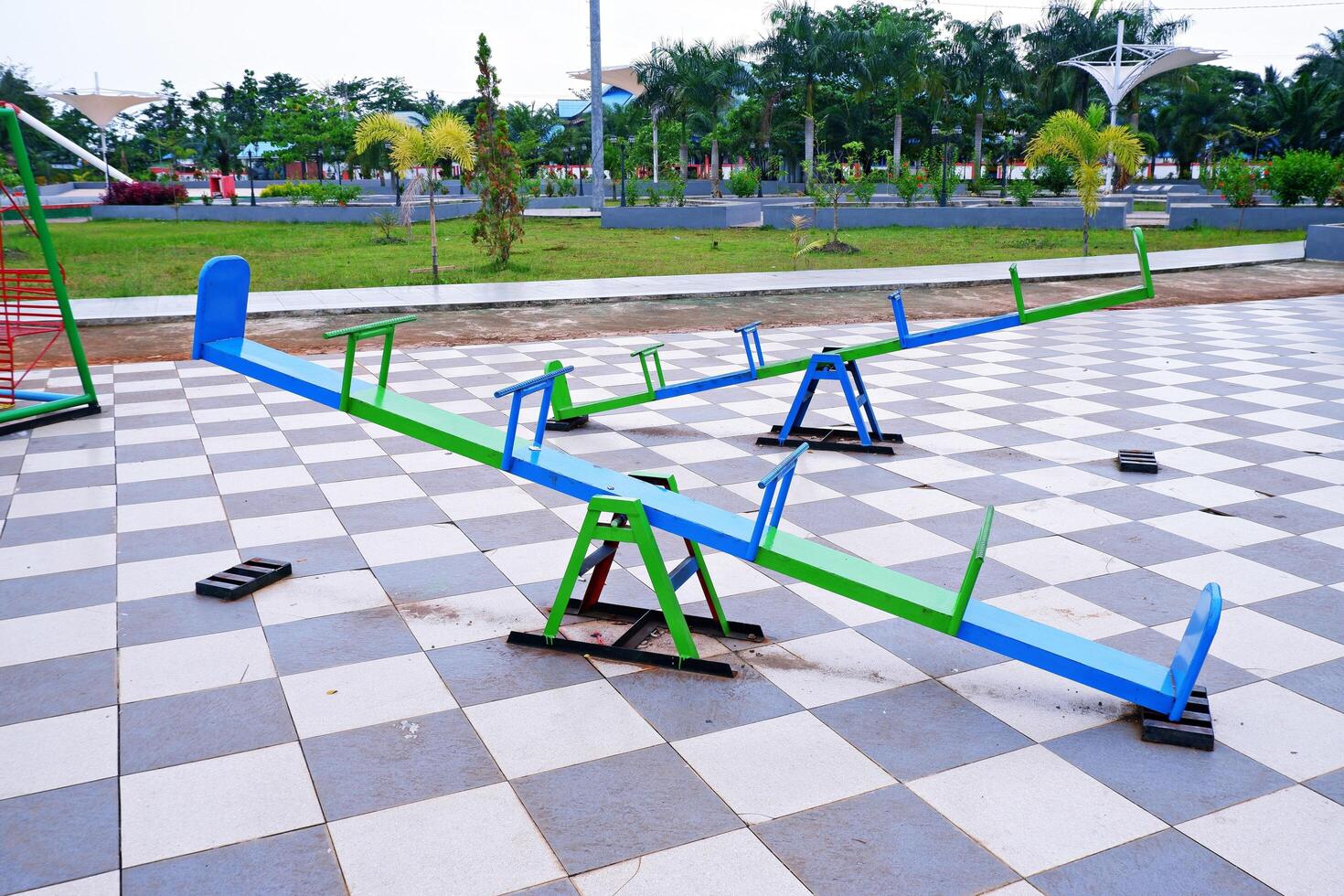 seesaw that can be played by 4 children. seesaw with a combination of blue and green colors. photo