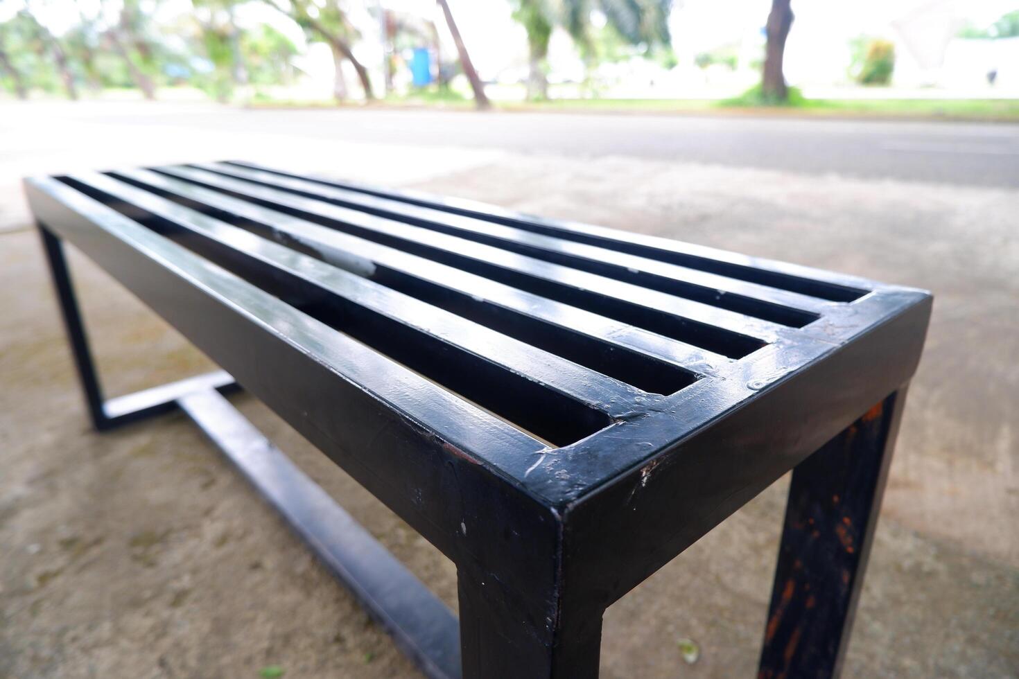 black bench made of iron. a bench with gaps in the seat photo