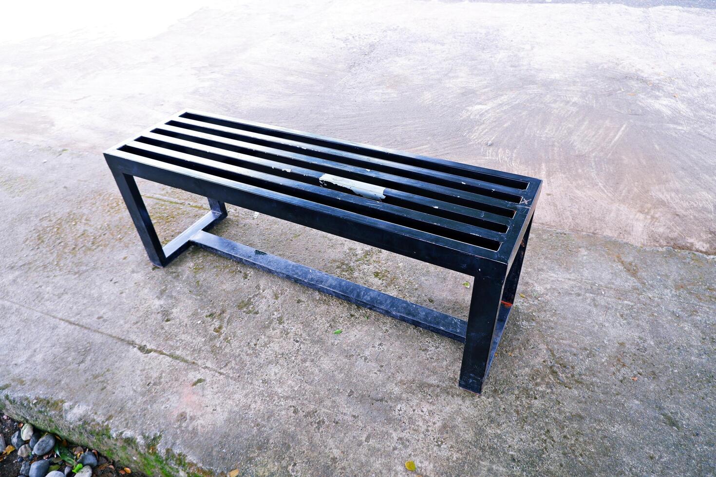 black bench made of iron. a bench with gaps in the seat photo