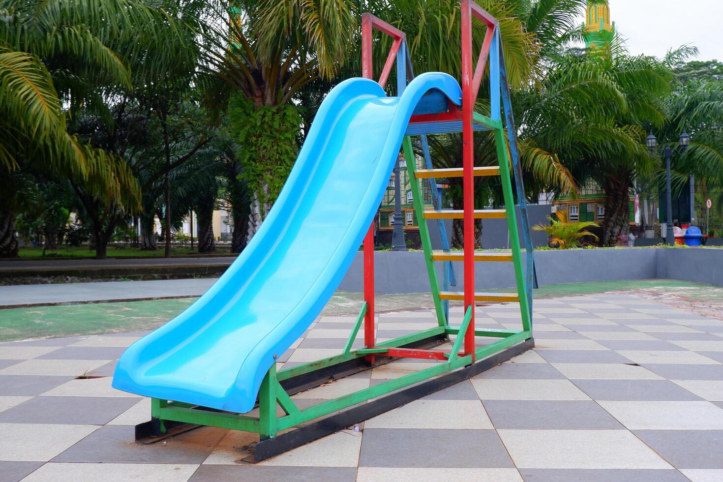 blue slide with iron stairs for children to play in the park photo