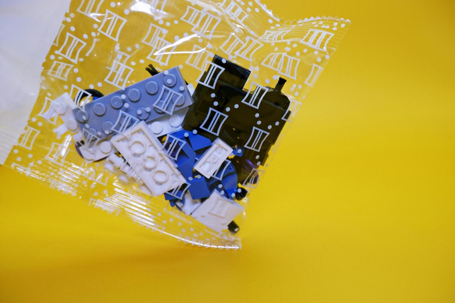 a collection of toy blocks still in plastic. a collection of toy blocks isolated on a yellow background. toys that are played by stacking them like stacking bricks. photo