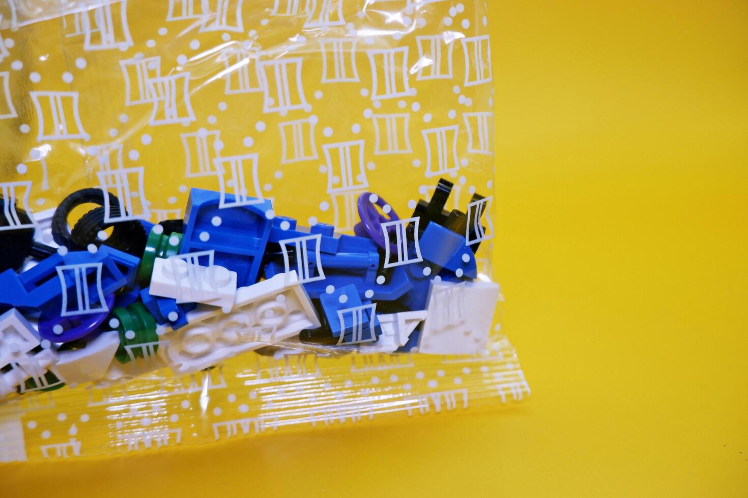 a collection of toy blocks still in plastic. a collection of toy blocks isolated on a yellow background. toys that are played by stacking them like stacking bricks. photo