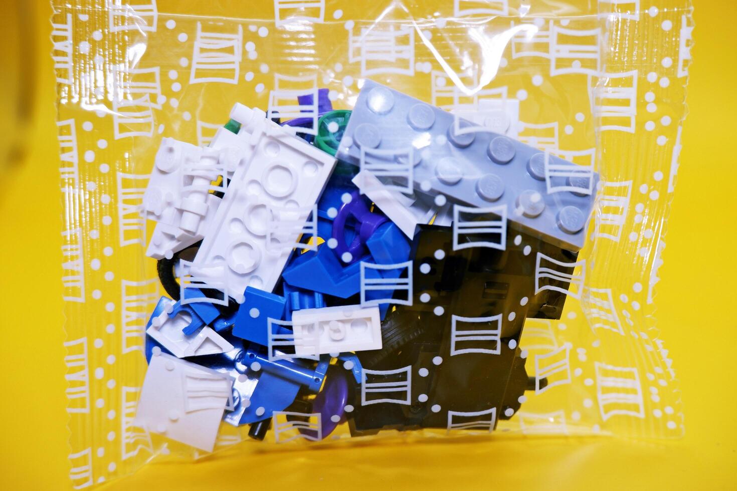 a collection of toy blocks still in plastic. a collection of toy blocks isolated on a yellow background. toys that are played by stacking them like stacking bricks. photo