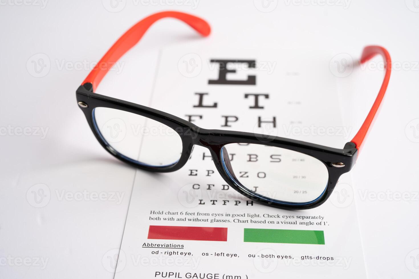 Glasses on eye testing exam chart to check eyesight accuracy of reading. photo