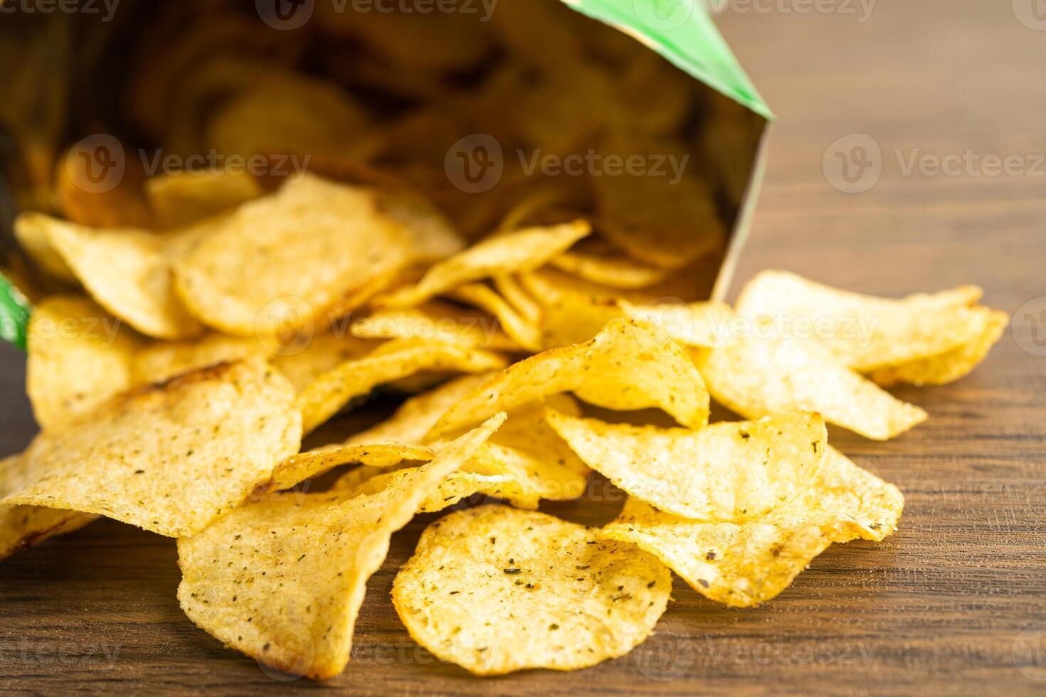 Potato chips, delicious spicy for crips, thin slice deep fried snack fast food in open bag. photo
