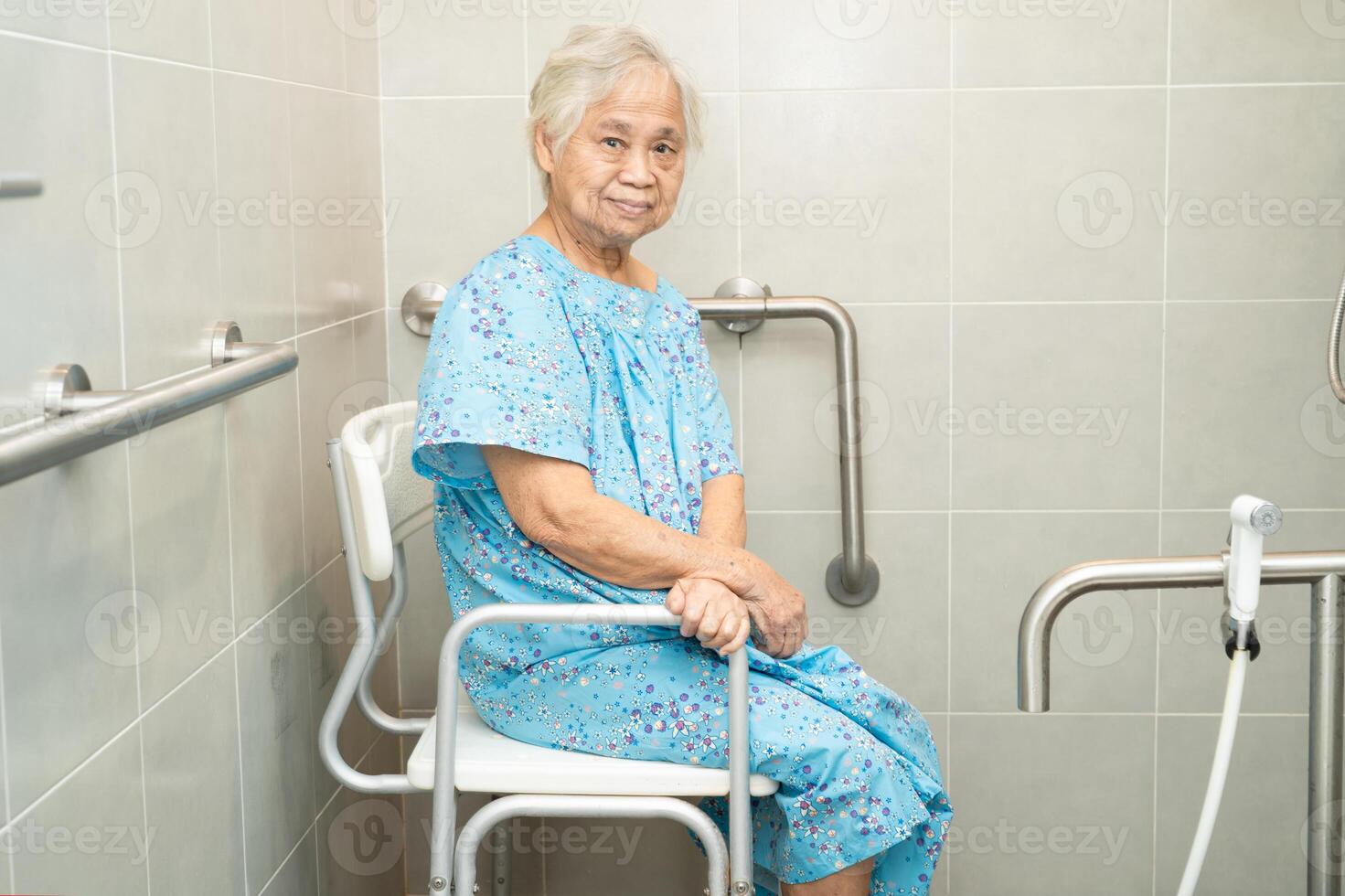 Asian elderly woman patient use toilet bathroom handle security in nursing hospital, healthy strong medical concept. photo