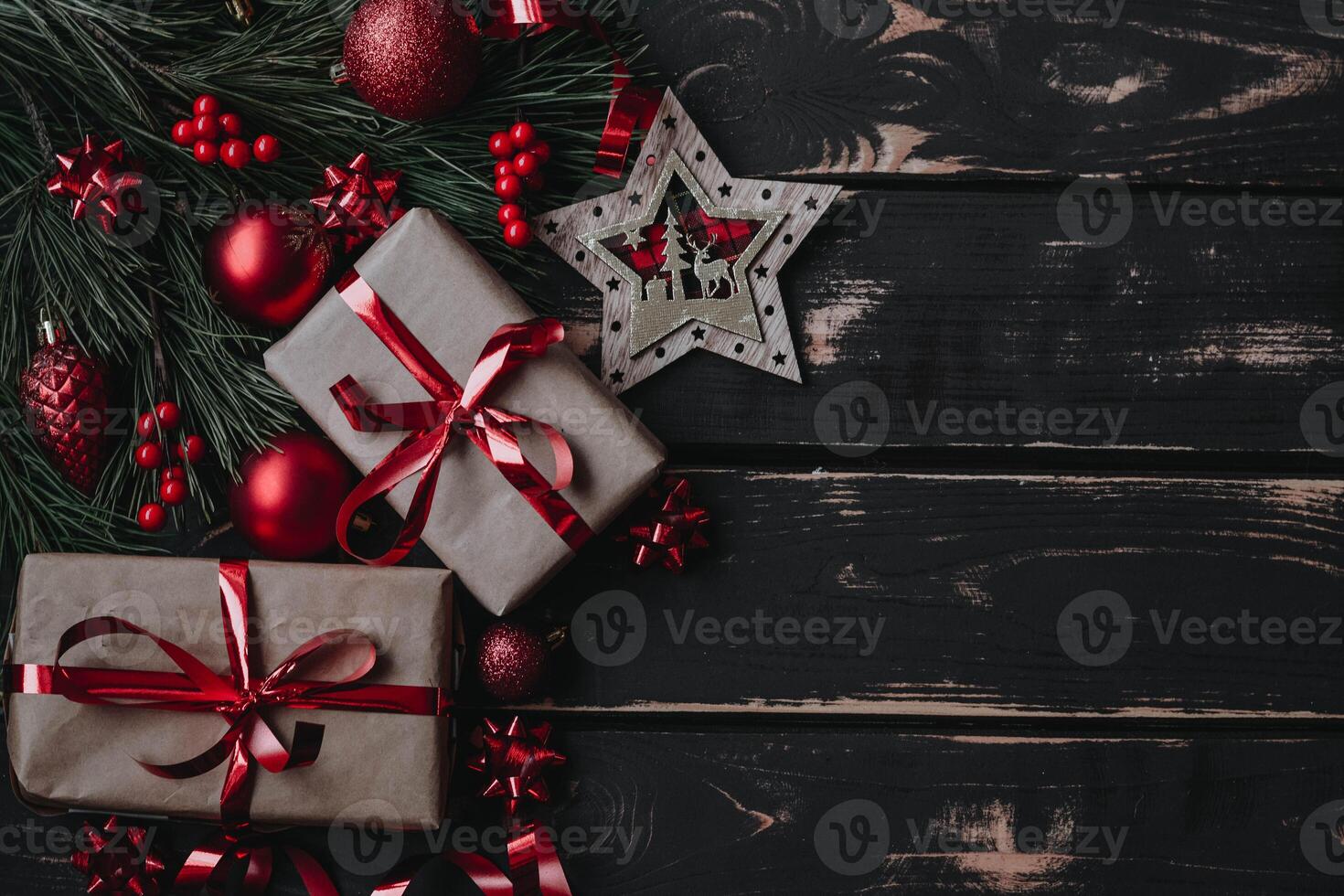 Top view photo Christmass flatlay gift boxes,red christmas tree toys and spruce brance on wooden background. Xmas backdrop with space for text.Copyspace.