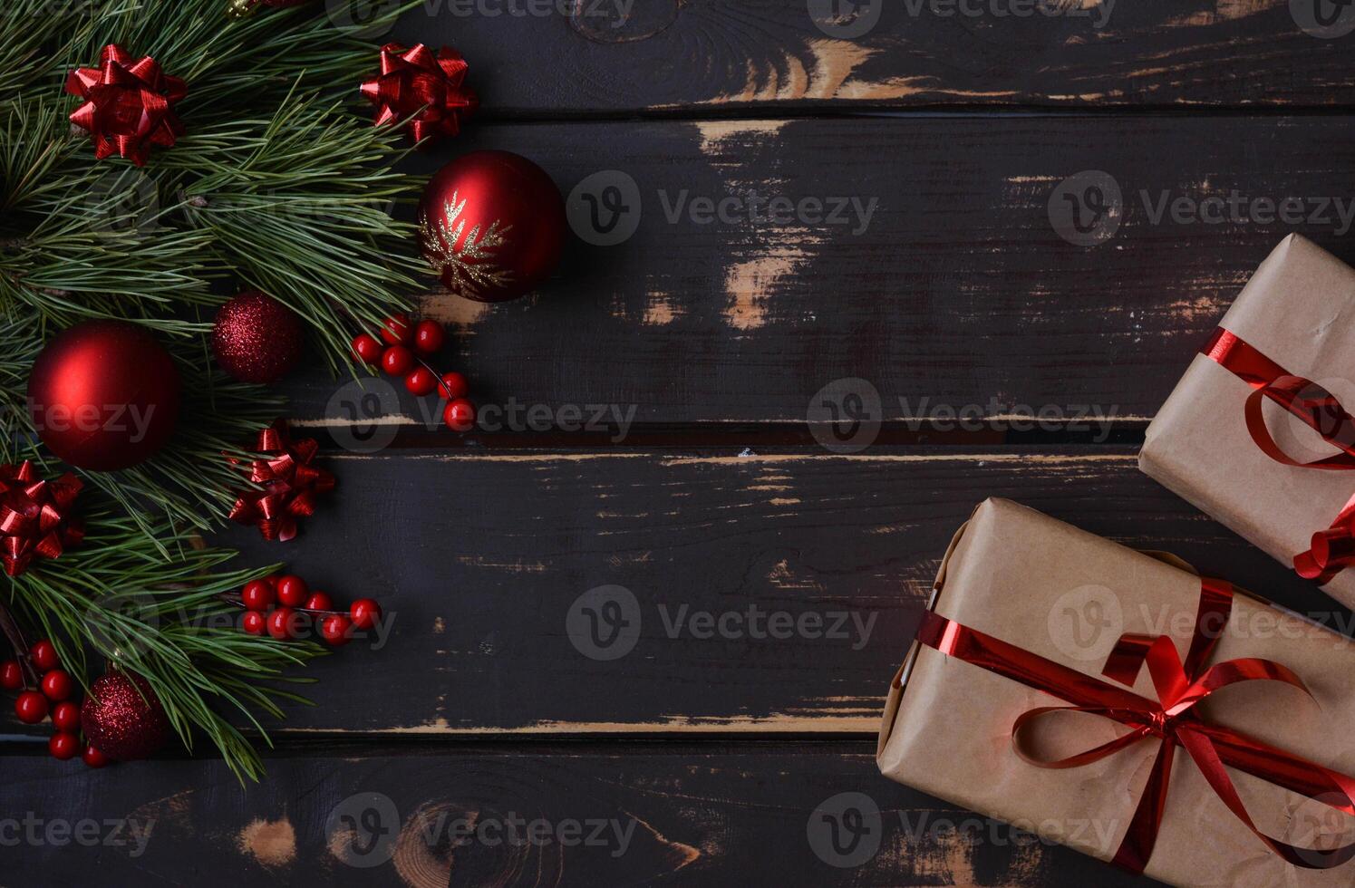 Top view photo Christmass flatlay gift boxes,red christmas tree toys and spruce brance on wooden background. Xmas backdrop with space for text.Copyspace.