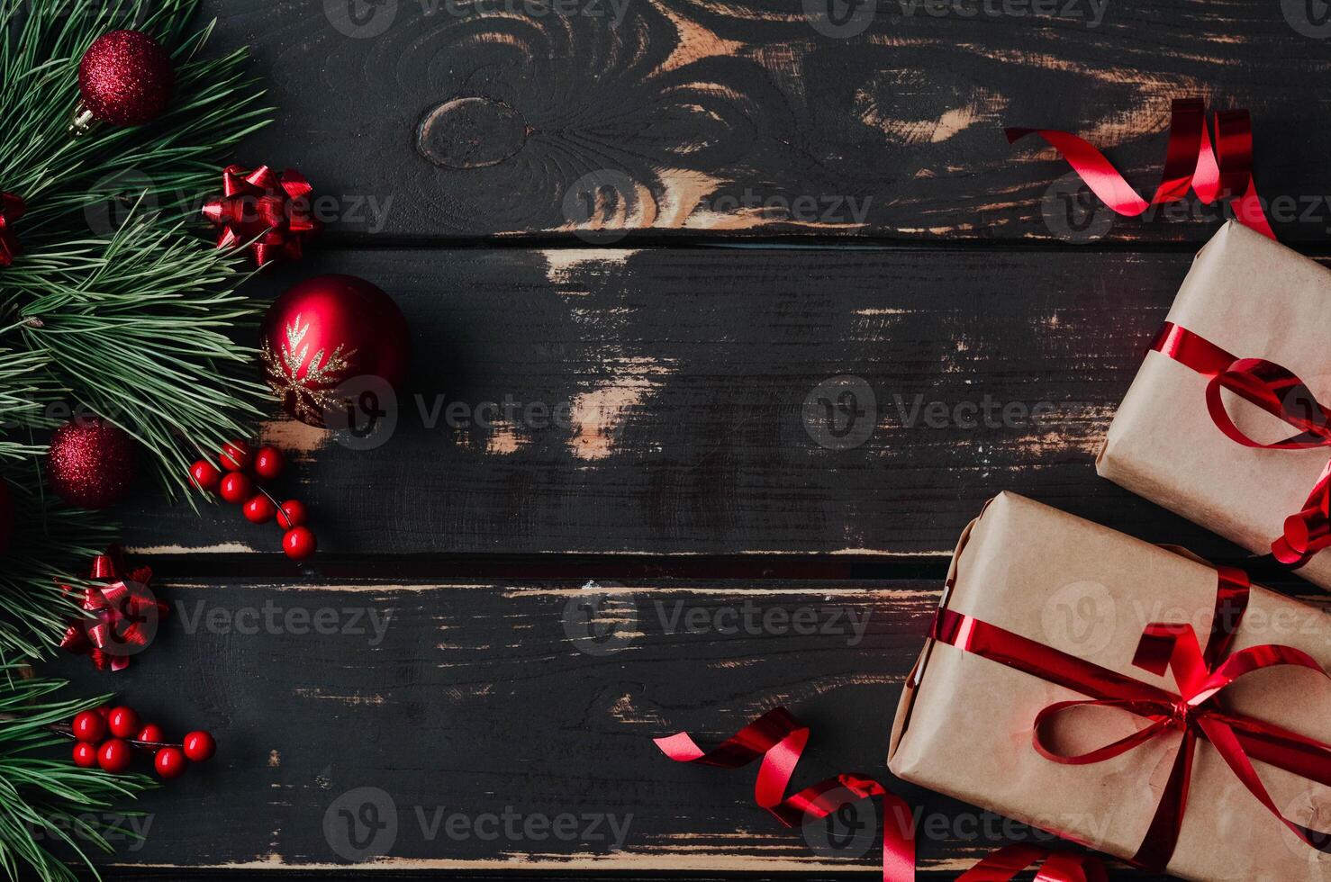 Top view photo Christmass flatlay gift boxes,red christmas tree toys and spruce brance on wooden background. Xmas backdrop with space for text.Copyspace.