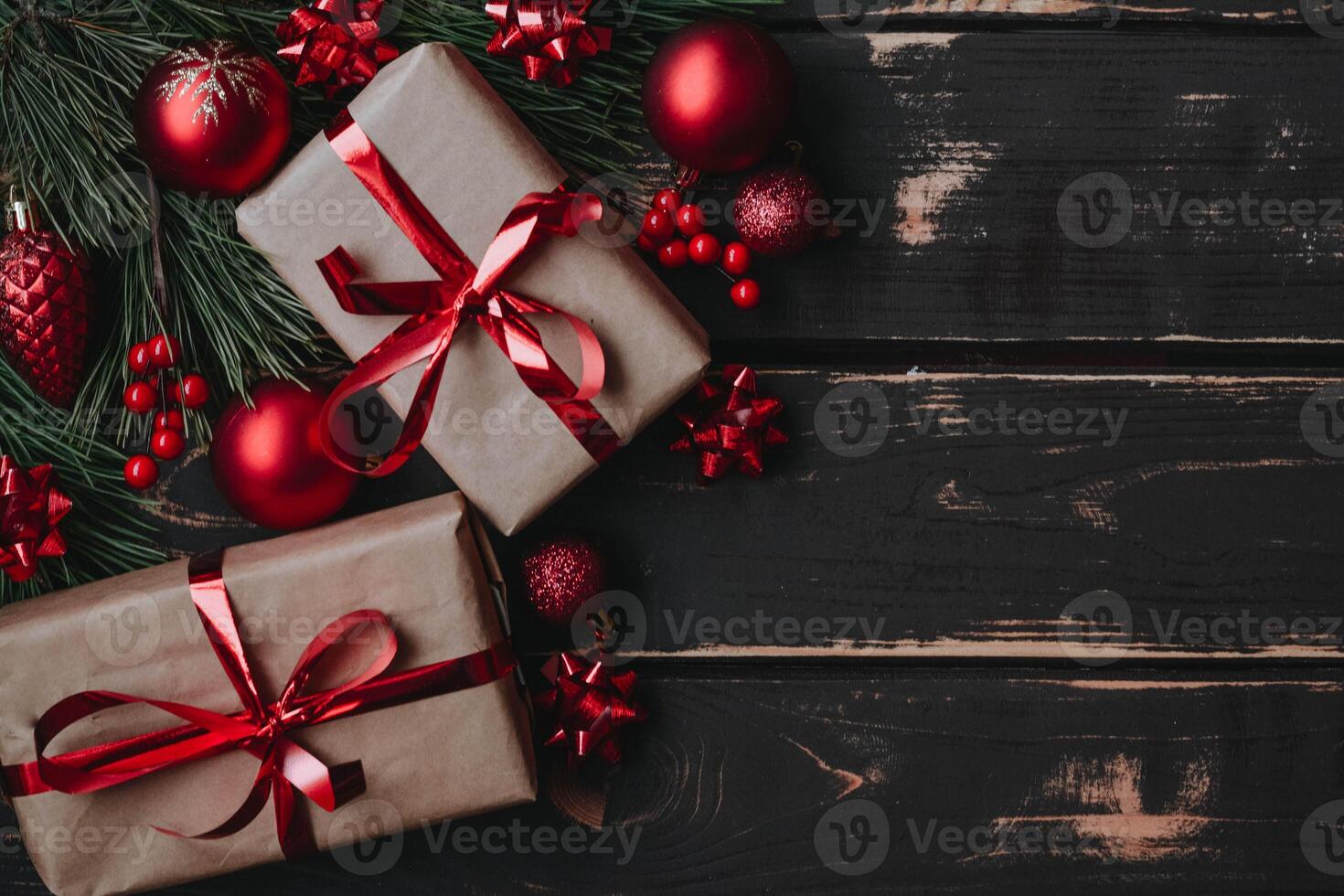 Top view photo Christmass flatlay gift boxes,red christmas tree toys and spruce brance on wooden background. Xmas backdrop with space for text.Copyspace.