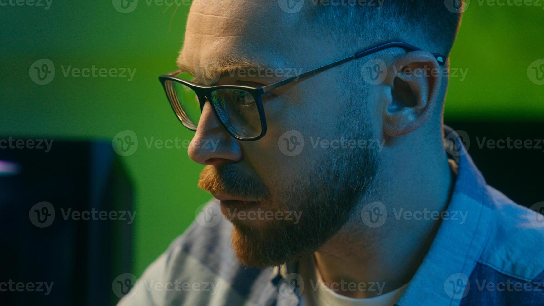 Concentrated Caucasian crypto trader man male late night work touching keys keyboard computer freelancer boy worker looking monitor writing statistics at home stock analyzing results digital banking photo