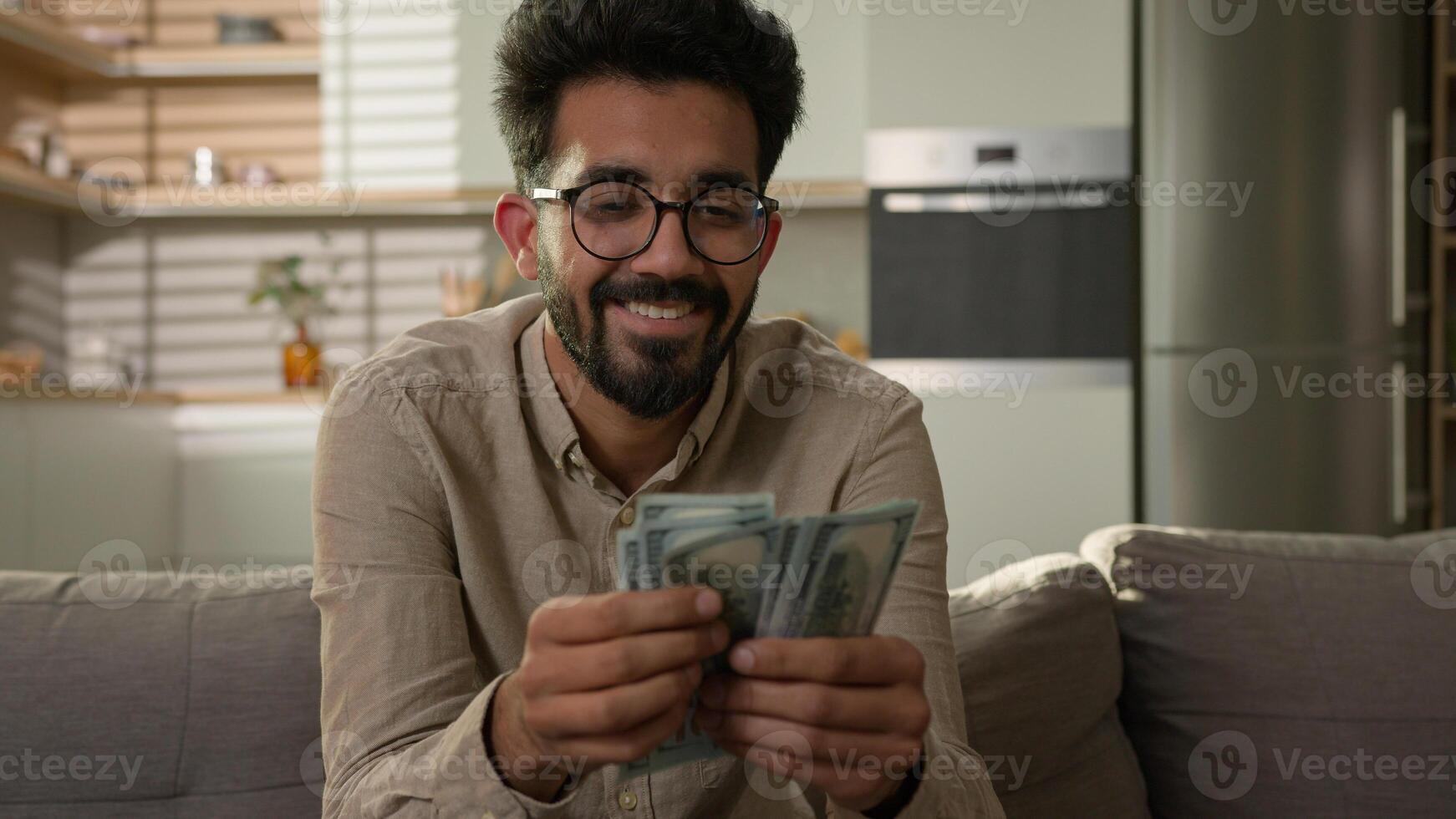 Rich wealthy Arabian Indian man happy guy homeowner businessman count money domestic budget finance prosperity salary benefit financial wealth counting dollars cash business investment at home kitchen photo