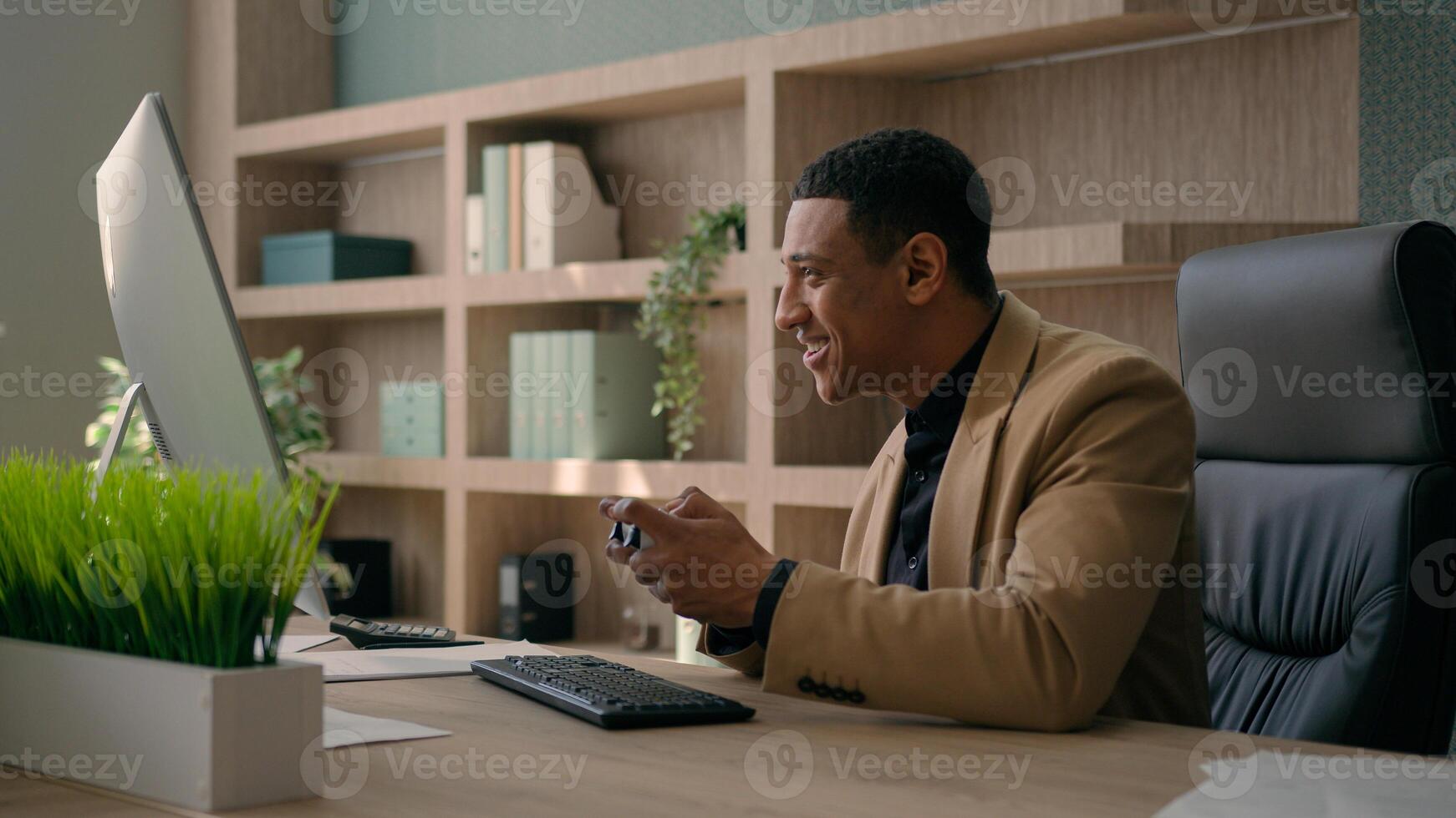 African American man worker funny businessman gamer play online game with joystick playing console football match on computer gaming addict employee manager ceo executive having fun in office photo