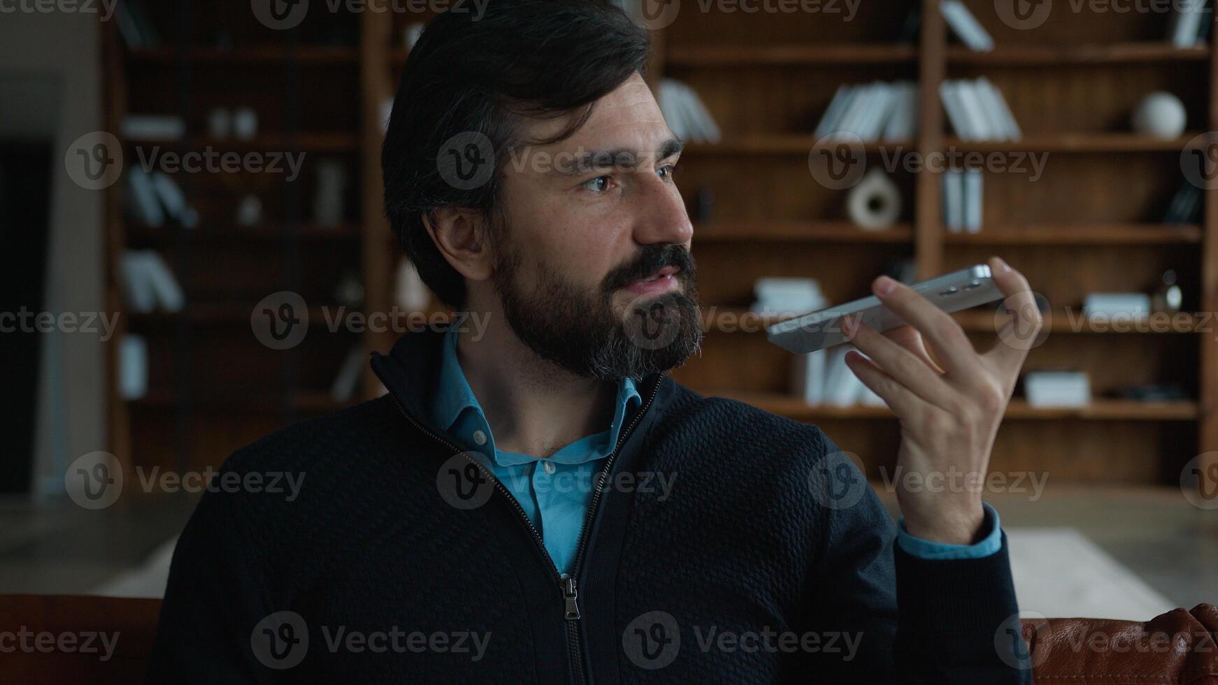 Successful serious Caucasian mature business man male businessman employer talking mobile phone saying smartphone using smart technologies dictate commands loudspeaker recording voice mail indoor room photo
