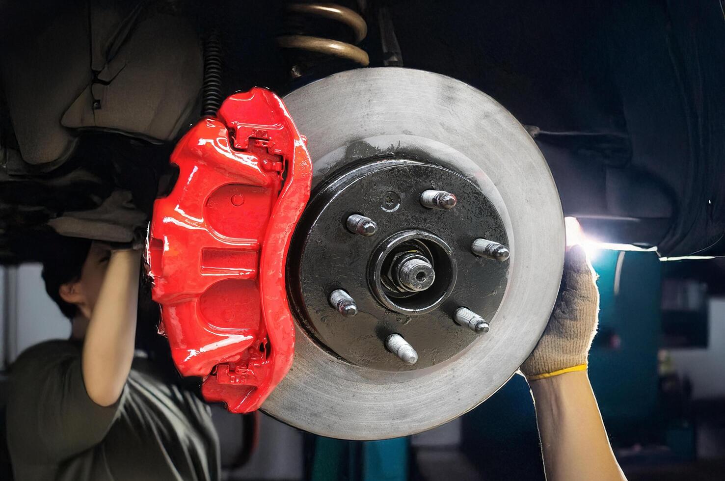 A man is working on a car's brake photo
