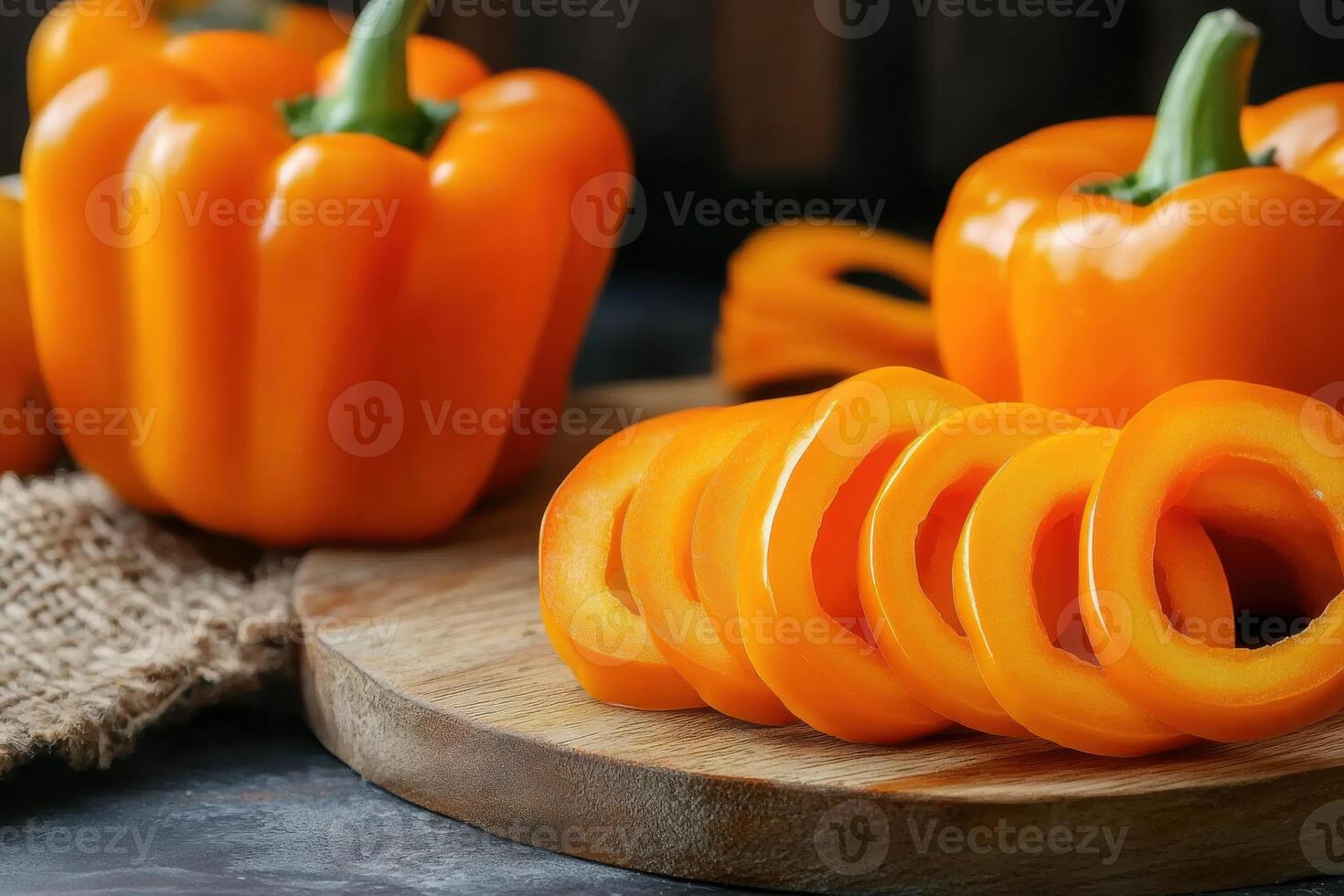 Freshly sliced orange bell peppers on a wooden cutting board, showcasing vibrant colors and healthy food preparation photo