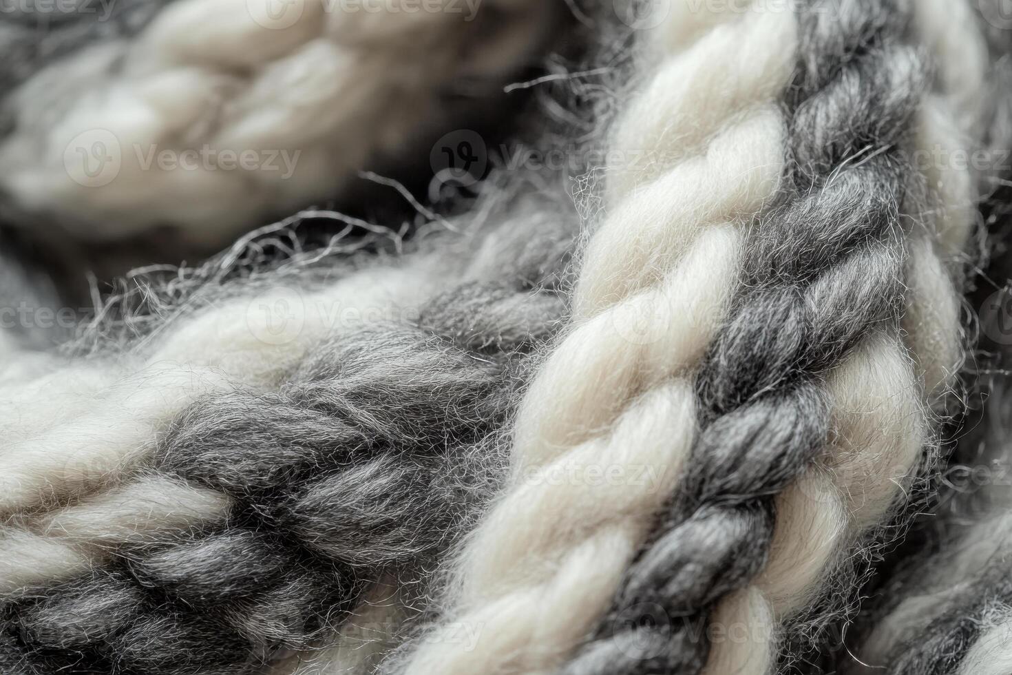 Close-up of intricately braided wool fibers in shades of gray and white on a textile background photo
