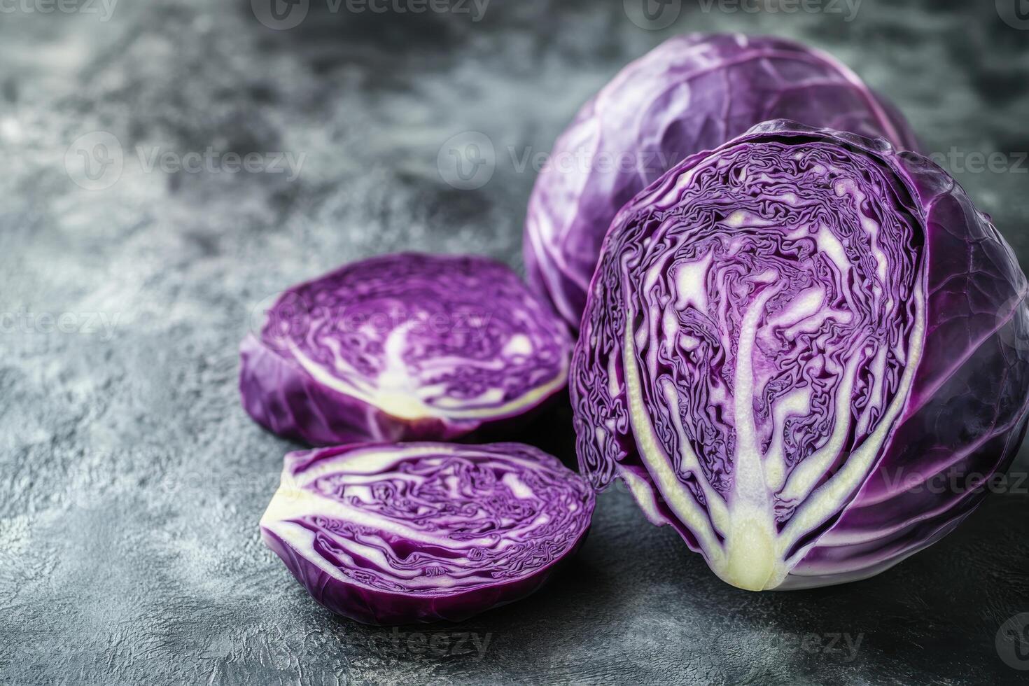 Freshly sliced purple cabbage on a textured gray surface showcasing vibrant colors and intricate patterns of the vegetable photo