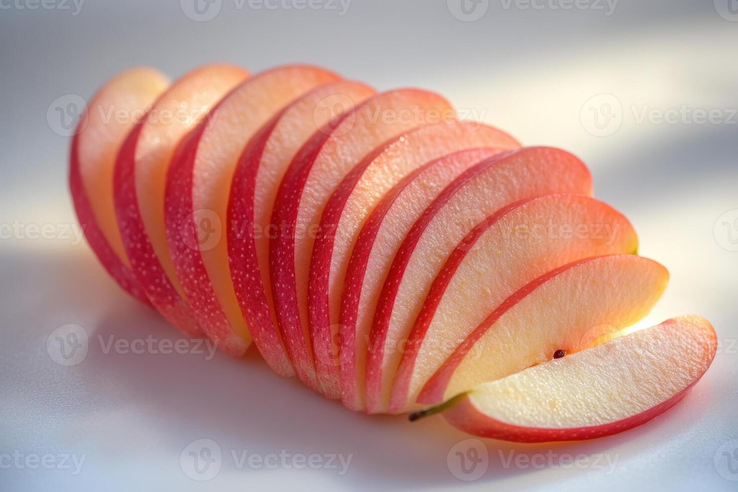 Freshly sliced red apples arranged neatly on a light surface, highlighting their vibrant colors and textures during daylight photo