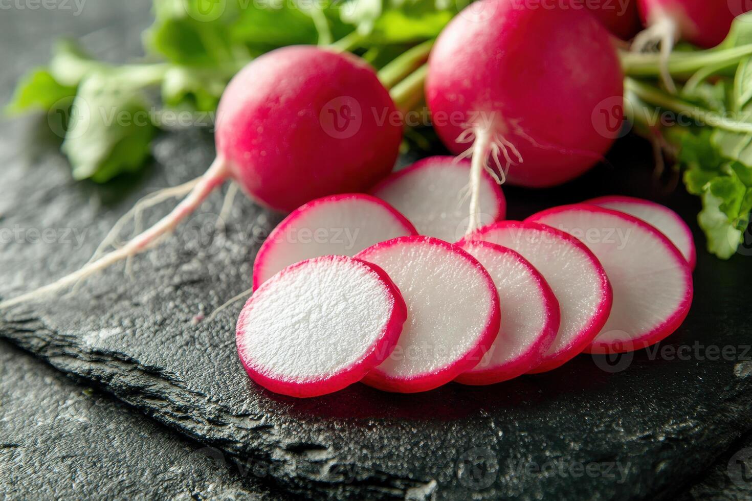 Freshly sliced radishes on a dark stone background in a bright kitchen setting showcasing vibrant colors and textures photo