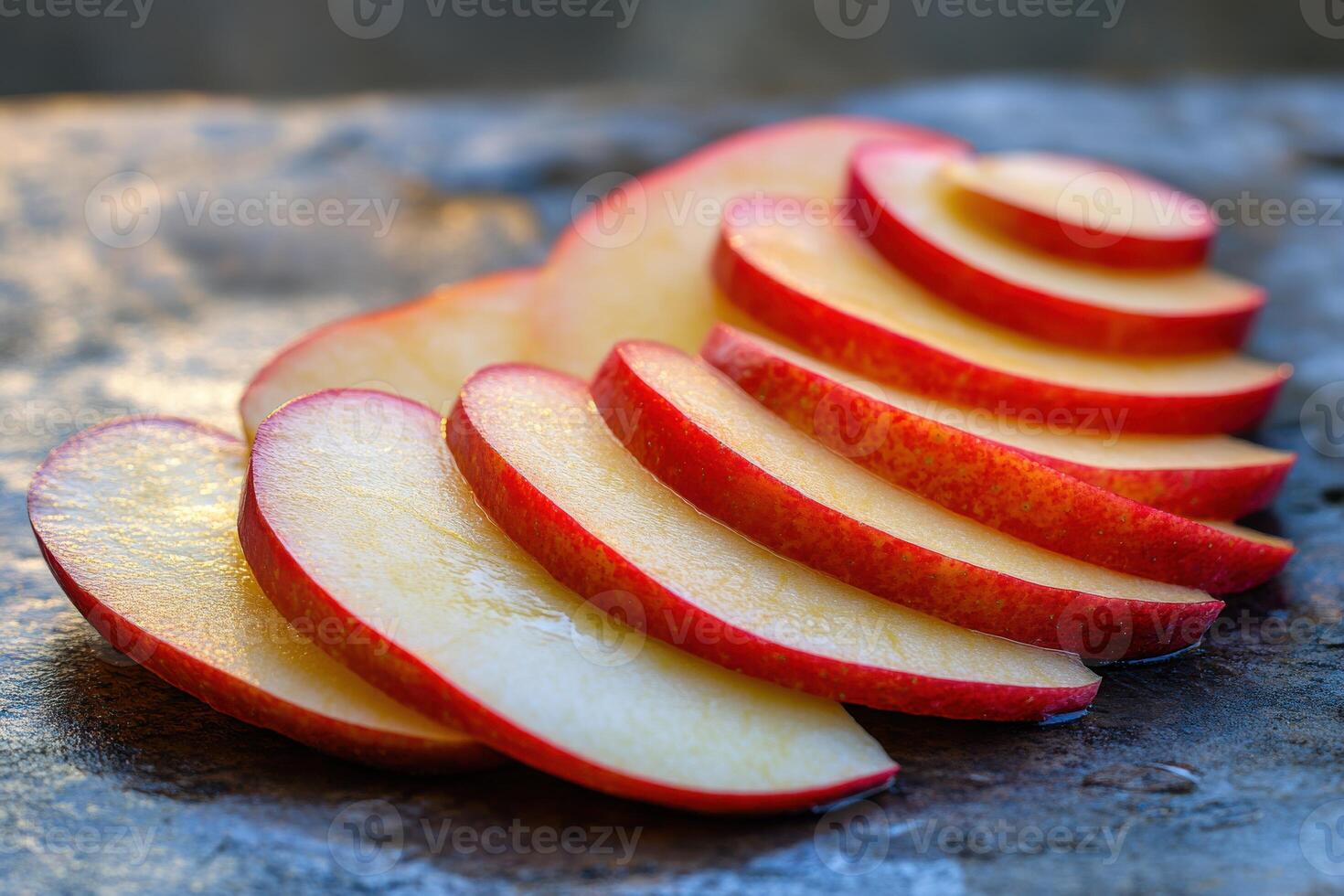 Freshly sliced red apple resting on a textured surface, showcasing vibrant colors and natural light, perfect for healthy snacks and presentations photo