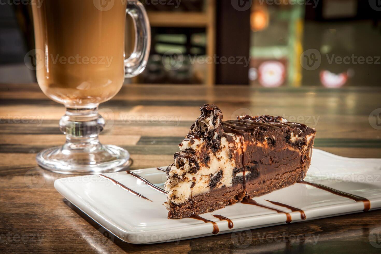 Decadent Chocolate Oreo Cheesecake with Drizzle Chocolate Sauce and Hot Chocolate Coffee mug served in tray dish isolated on table side view of cafe baked dessert food photo