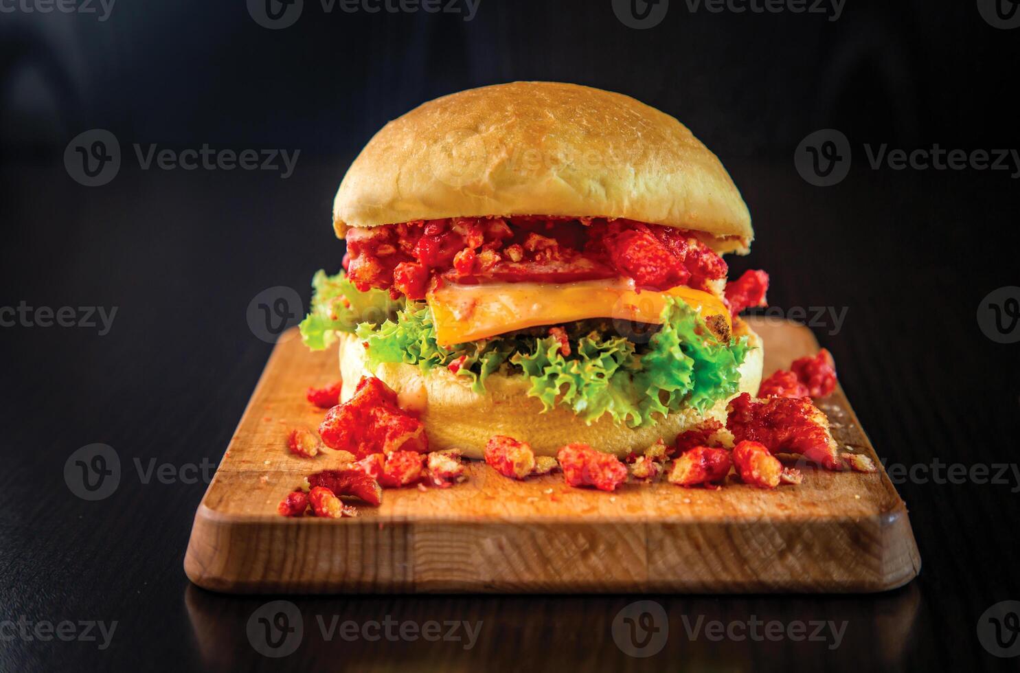 picante cheetos hamburguesa con Derretido queso y lechuga aislado en de madera tablero lado ver de especias comida rápida foto