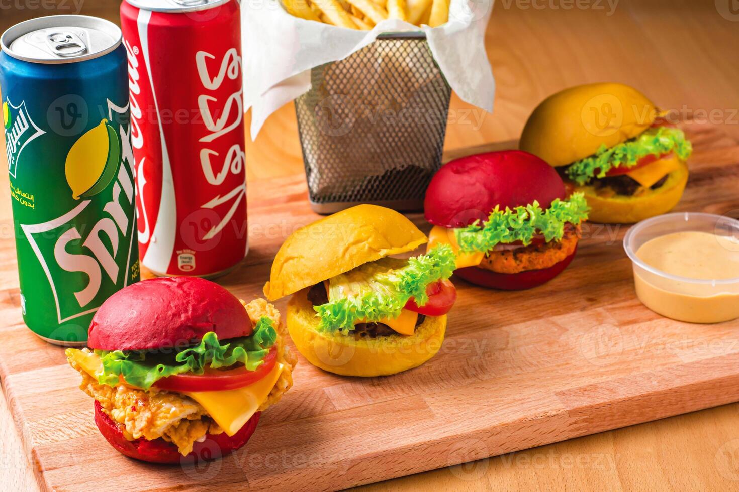 Mini Sliders Combo with Fries, dip sauce and Drinks coke and sprite cans isolated on wooden board side view of fast food meal photo
