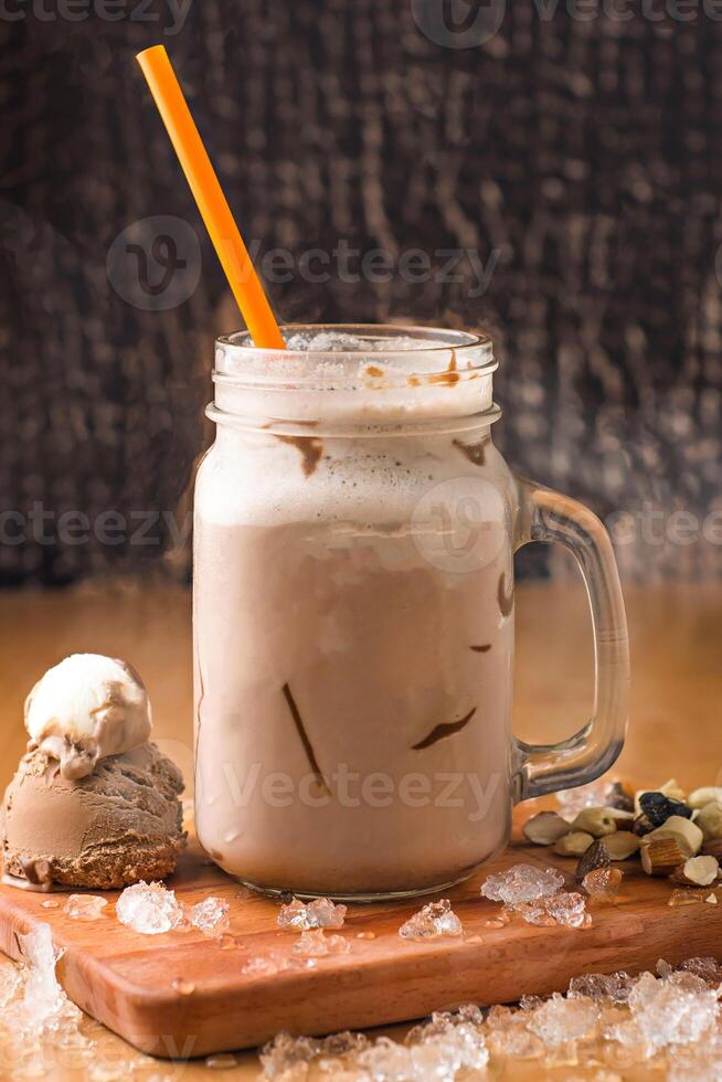 Chocolate Peanut Butter Milkshake with Ice Cream, nuts and chocolate chip served in jar isolated on wooden board side view of milkshake photo