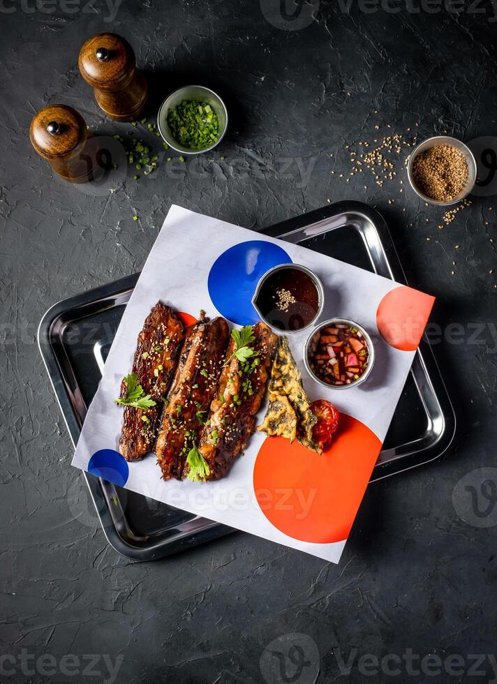 Hickory Bbq Beef Brisket Belly with Dipping Sauces and sesame seeds served in tray isolated on grey background top view of A la carte Food platter photo